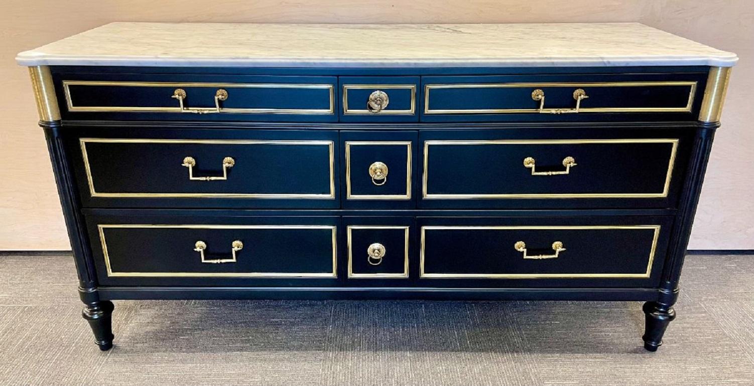 Hollywood Regency ebony commode, dresser. Maison Jansen Style. A fine Carrera White and Gray veined Marble Top supported by a group of three small center drawer all bronze framed with bronze pulls flanked by three by three much larger bronze framed