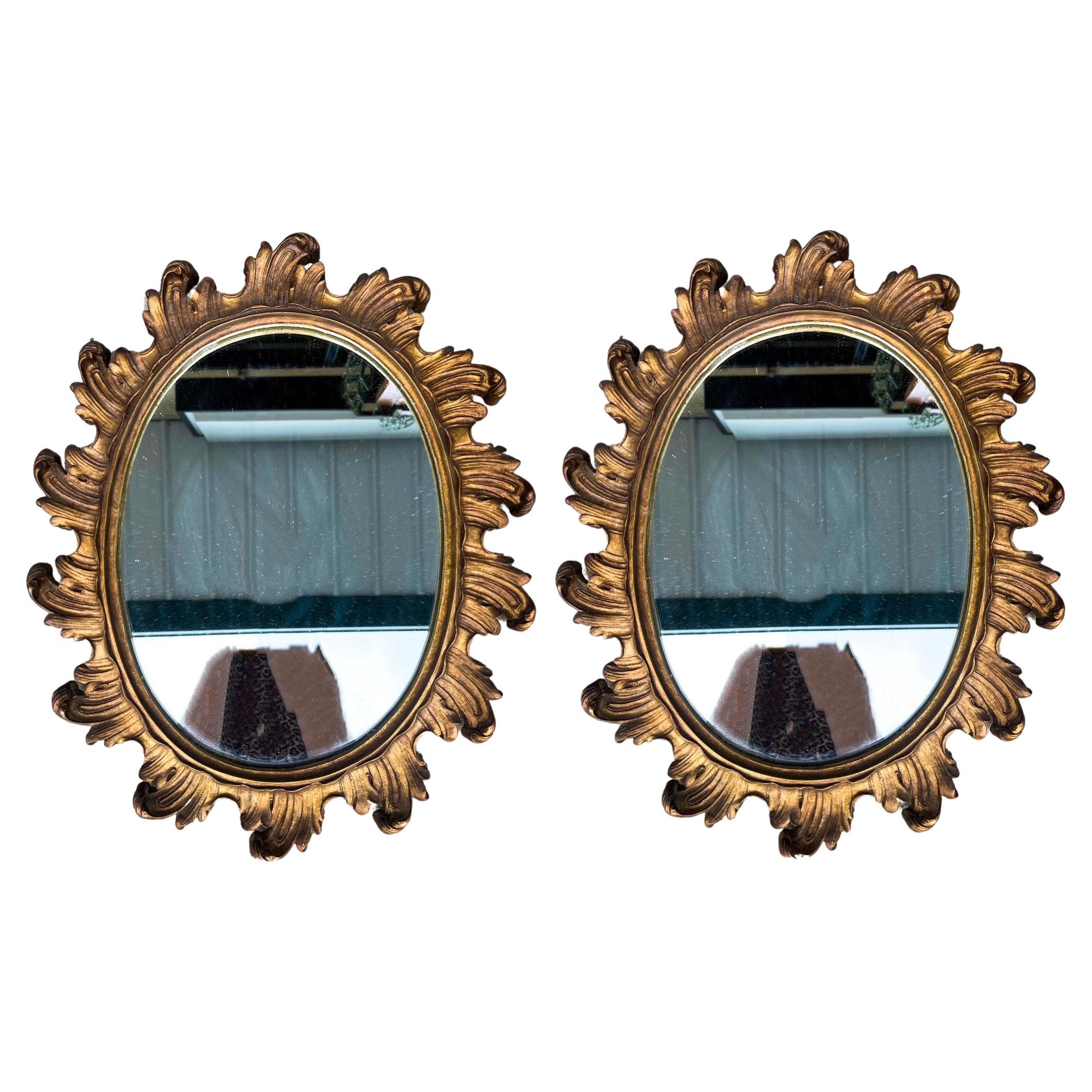 Il s'agit d'une belle paire de miroirs en bois doré sculpté à bords festonnés de l'époque Hollywood Regency. Les dos sont doublés de feutre. Ils ne portent aucune marque et sont en très bon état.