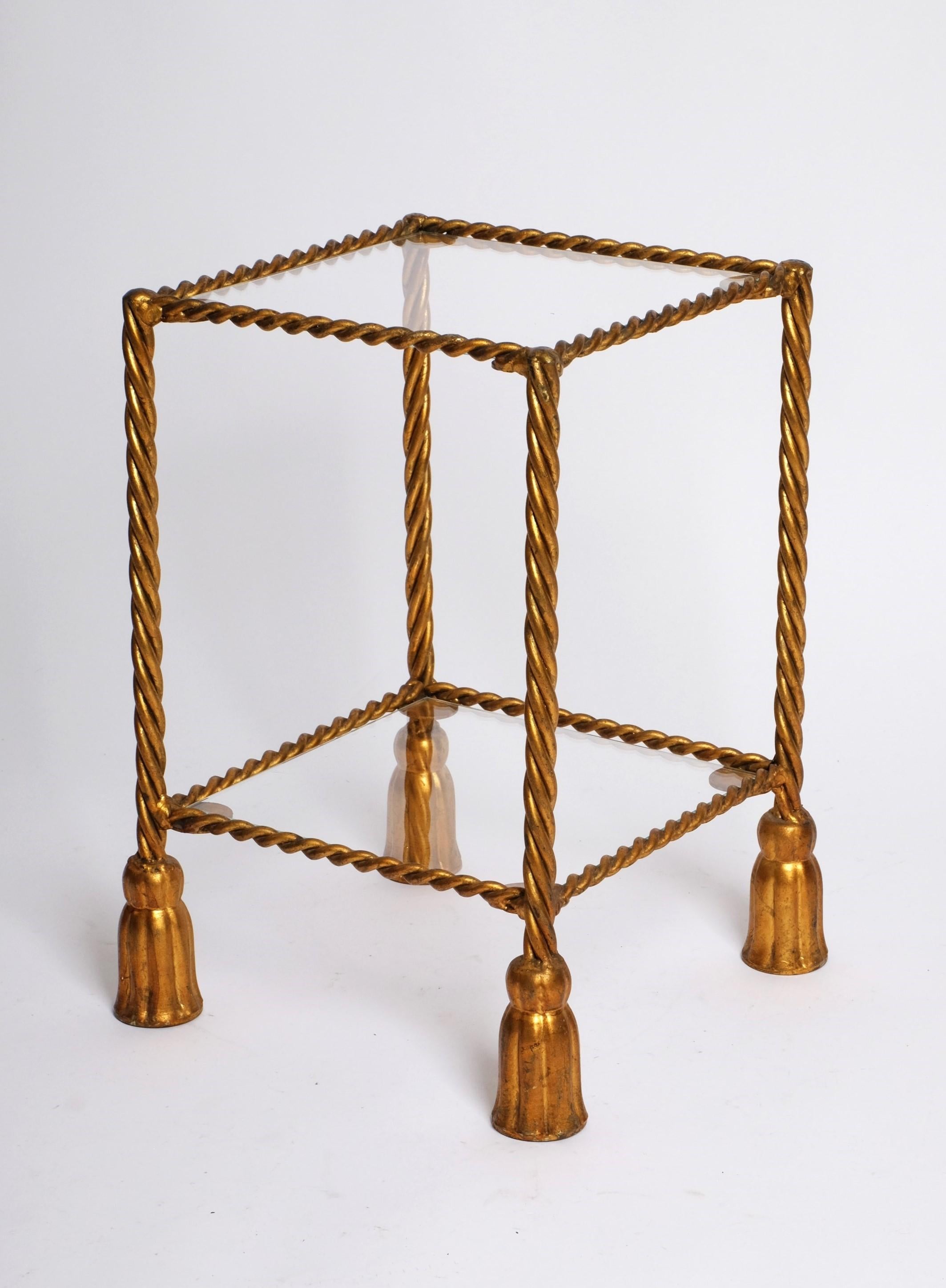 Vintage Hollywood Regency etagere or side table attributed to Li Puma with square glass top and lower shelf. Stands on four gilt metal legs with faux twisted rope ending in tasseled feet (1960s). Beautiful design from the 1960s. Very