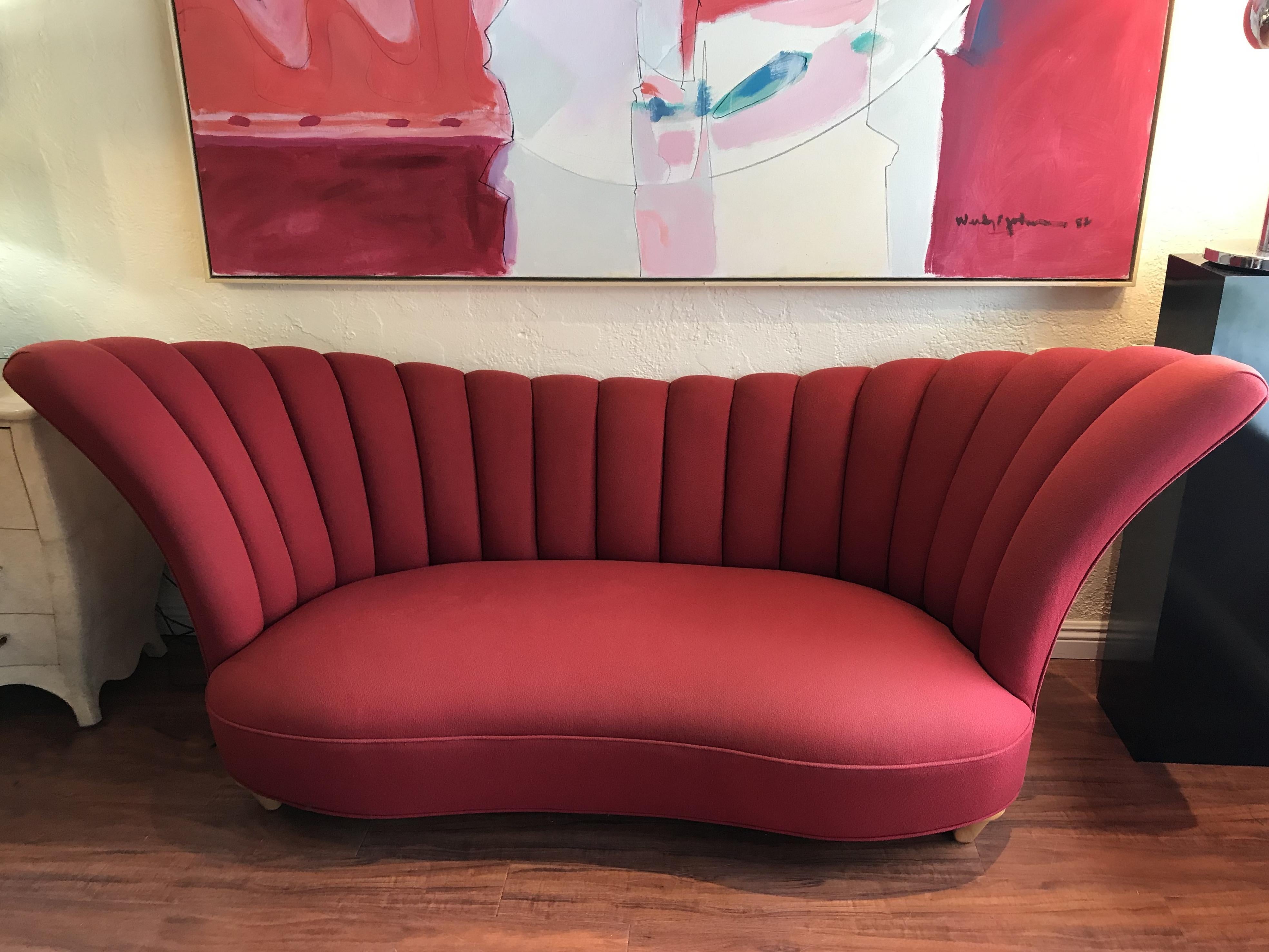 Glamorous fan back sofa upholstered with channels in raspberry color fabric sitting on sycamore conic shape front legs.
The depth mentioned in the dimensions is the total depth, the seat depth is 24