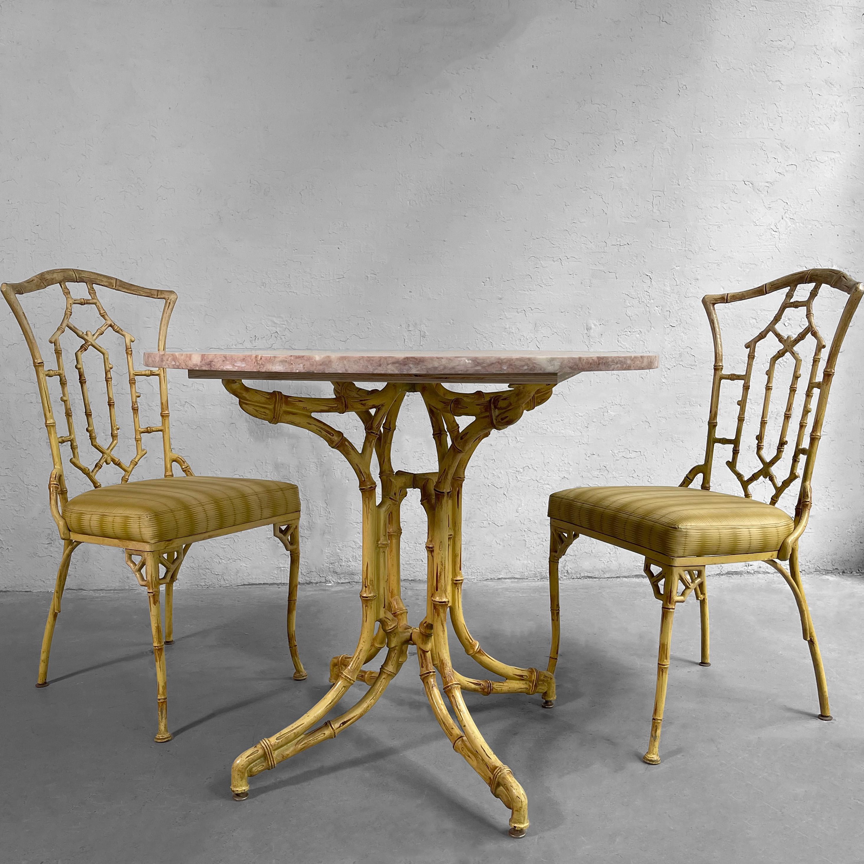 Midcentury, Hollywood Regency, faux bamboo, café dining set consists of two cast aluminum side chairs and a table base for indoor and outdoor use. The marble top shown is for reference and is not part of this set. The table base is 30 inches height