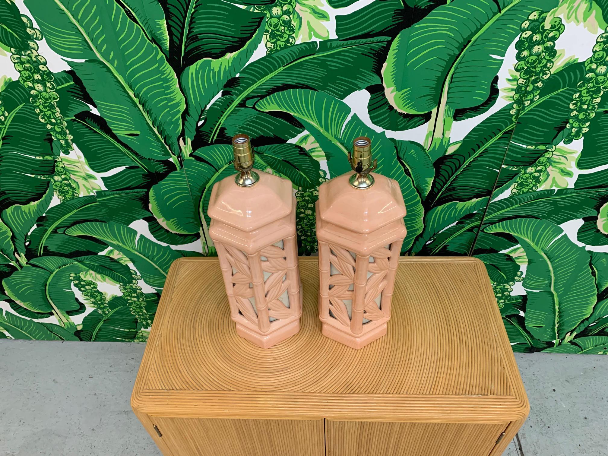 Pair of vintage ceramic table lamps feature faux bamboo detailing and lights within the body. Can be lit with either the main bulb, the body, or both. Very good condition with no cracks or chips. As with all vintage pieces, may exhibit scuffs or