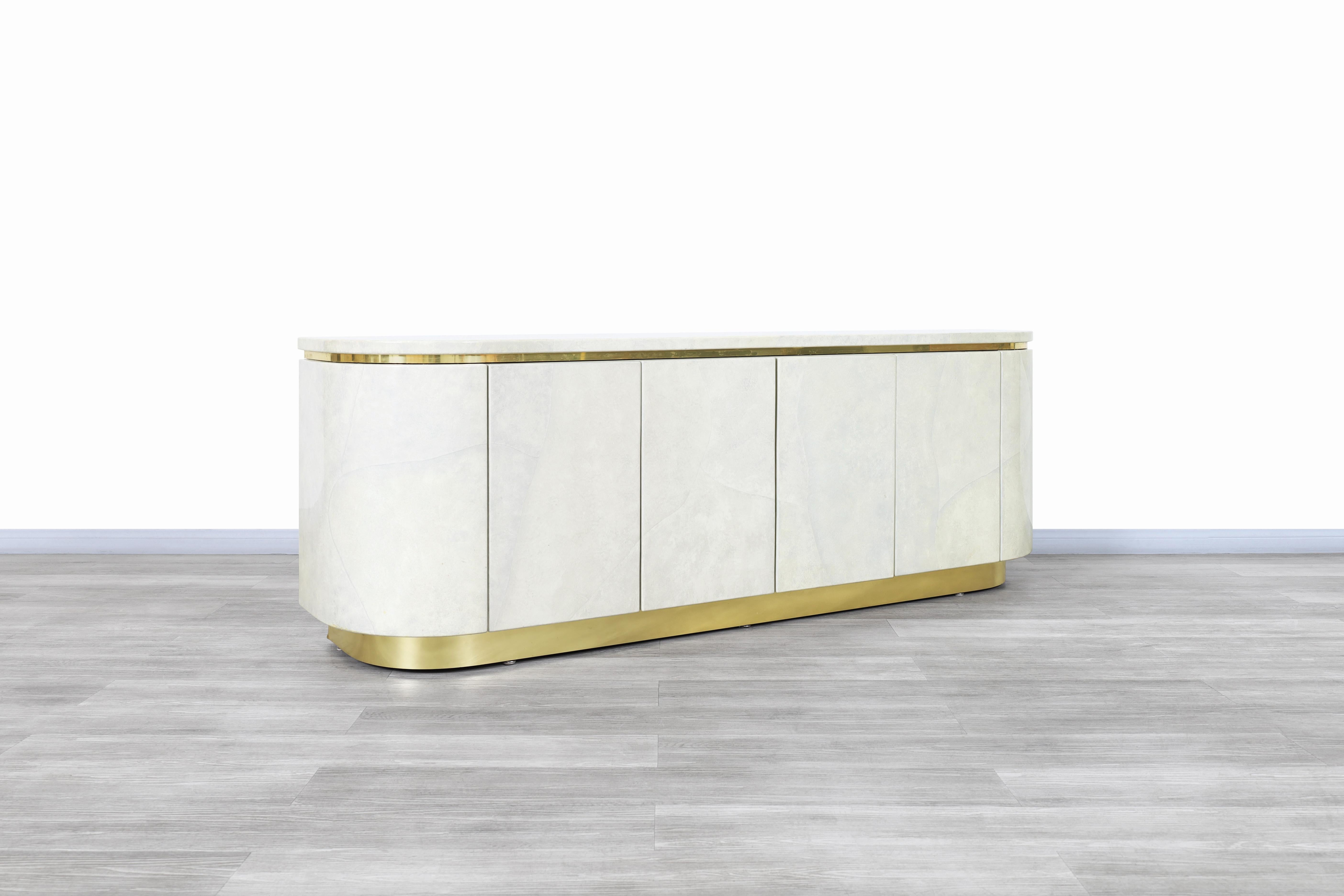 Beautiful Hollywood Regency faux goatskin and brass sideboard manufactured by Mastercraft in the United States, circa 1980s. This sideboard represents all the elegance and style of Hollywood Regency, which we can appreciate through the minimalism of