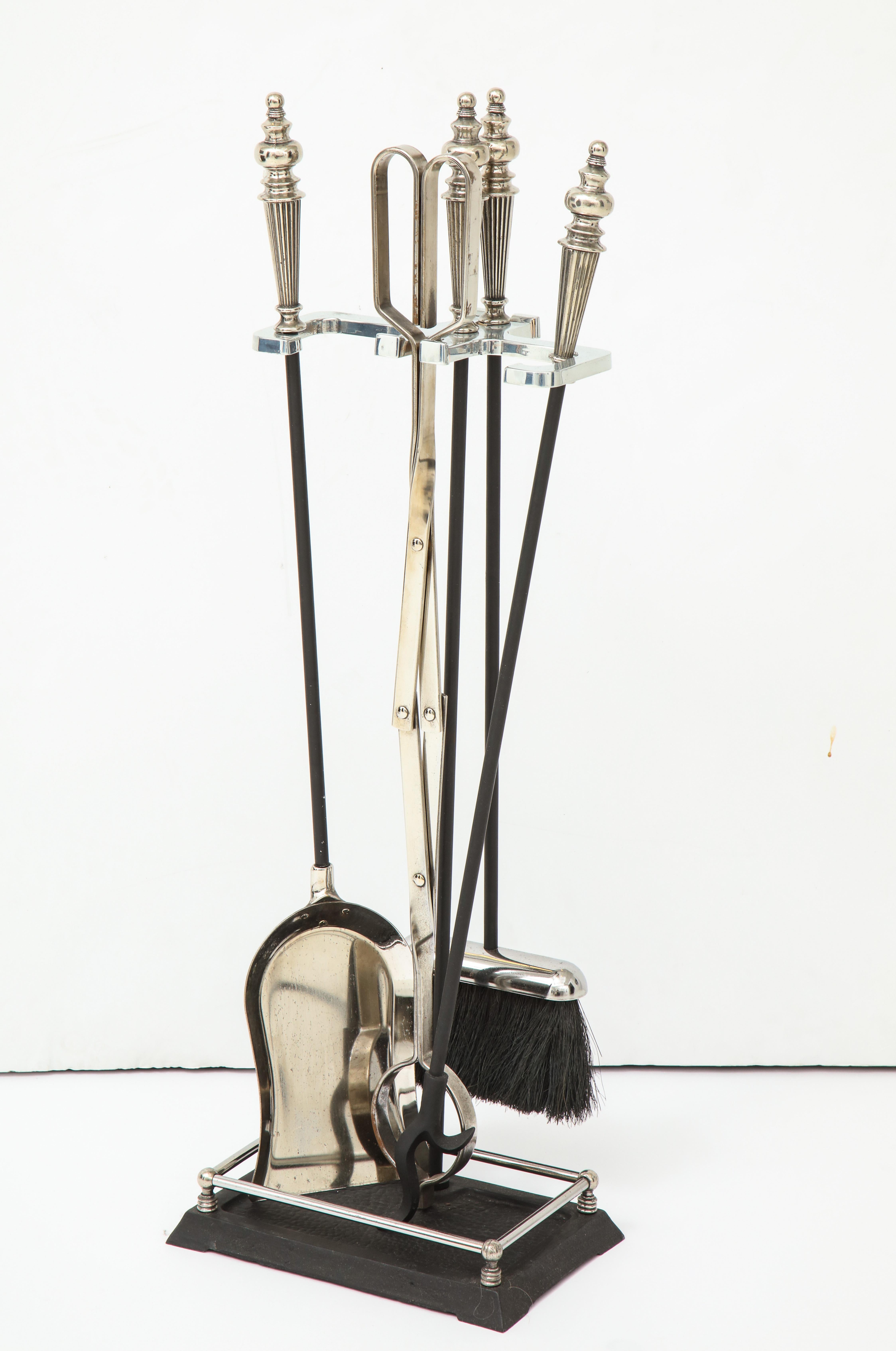 Set of Hollywood Regency fire tools with polished nickel turned finials and blackened steel construction. Set includes stand, poker, broom, tongs, and shovel.