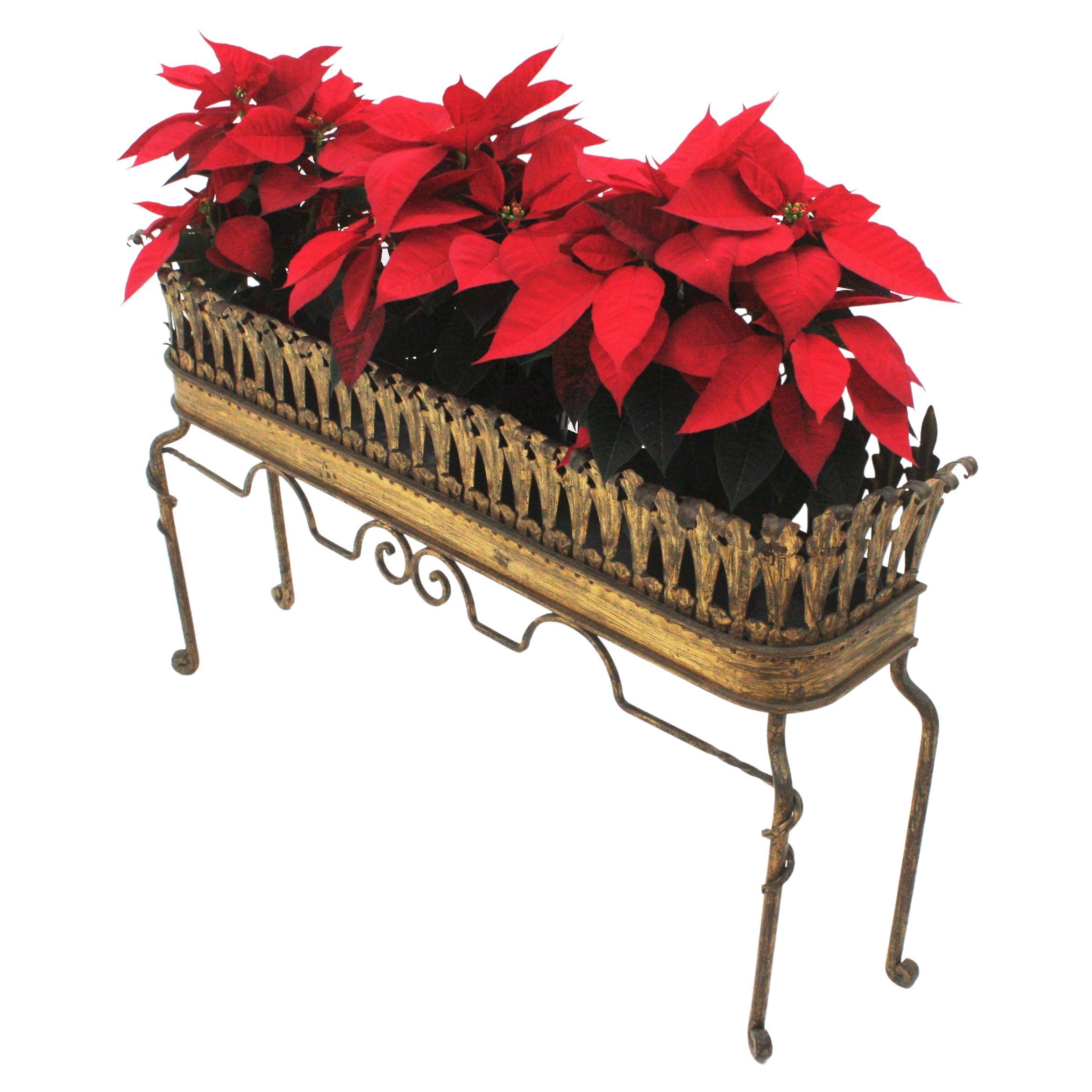Large Hollywood Regency rectangular tall jardinière, Gold leaf, gilt iron, France, 1940s.
This elegant tall plant stand is entirely made by hand. Features a leafed rectangular shaped planter comprised by iron leaves. It stands up on four scroll