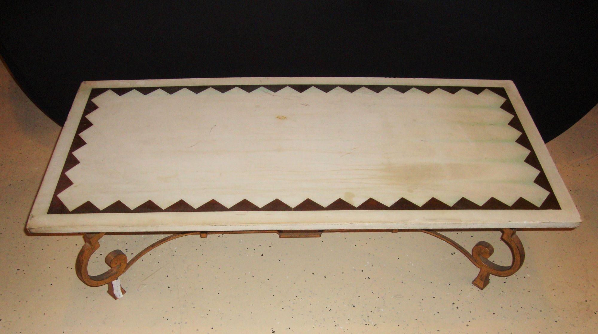 Table basse française à plateau de marbre dans le style du milieu du siècle, avec une base en fer doré et des pieds en forme de tronc d'éléphant.