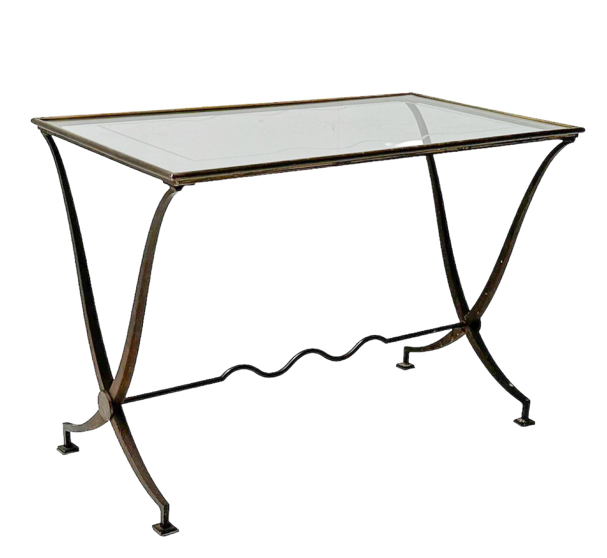 Stunning and elegant Hollywood Regency coffee table or cocktail table.
Striking French design from the 1970s.
Patinated iron and brass top with original glass top.
Top has some scratches from putting on drinks!
This wonderful Hollywood Regency