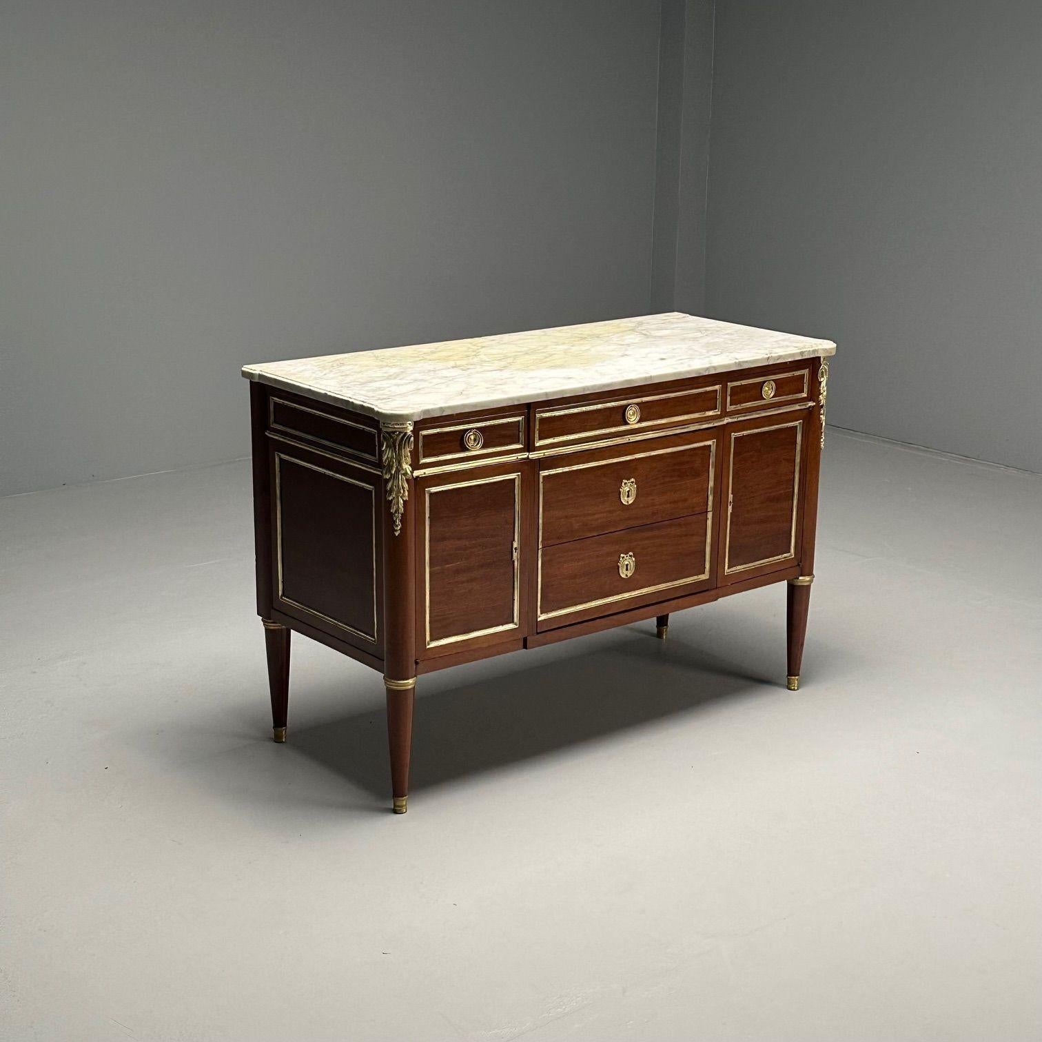 Hollywood Regency, French Louis XVI Style Commode, Mahogany, Marble, France, 1920s
 
Maison Jansen inspired Mahogany commode with bronze mounts on the foot corners and bronze framing on all drawers and sides. This finely crafted commode is fully