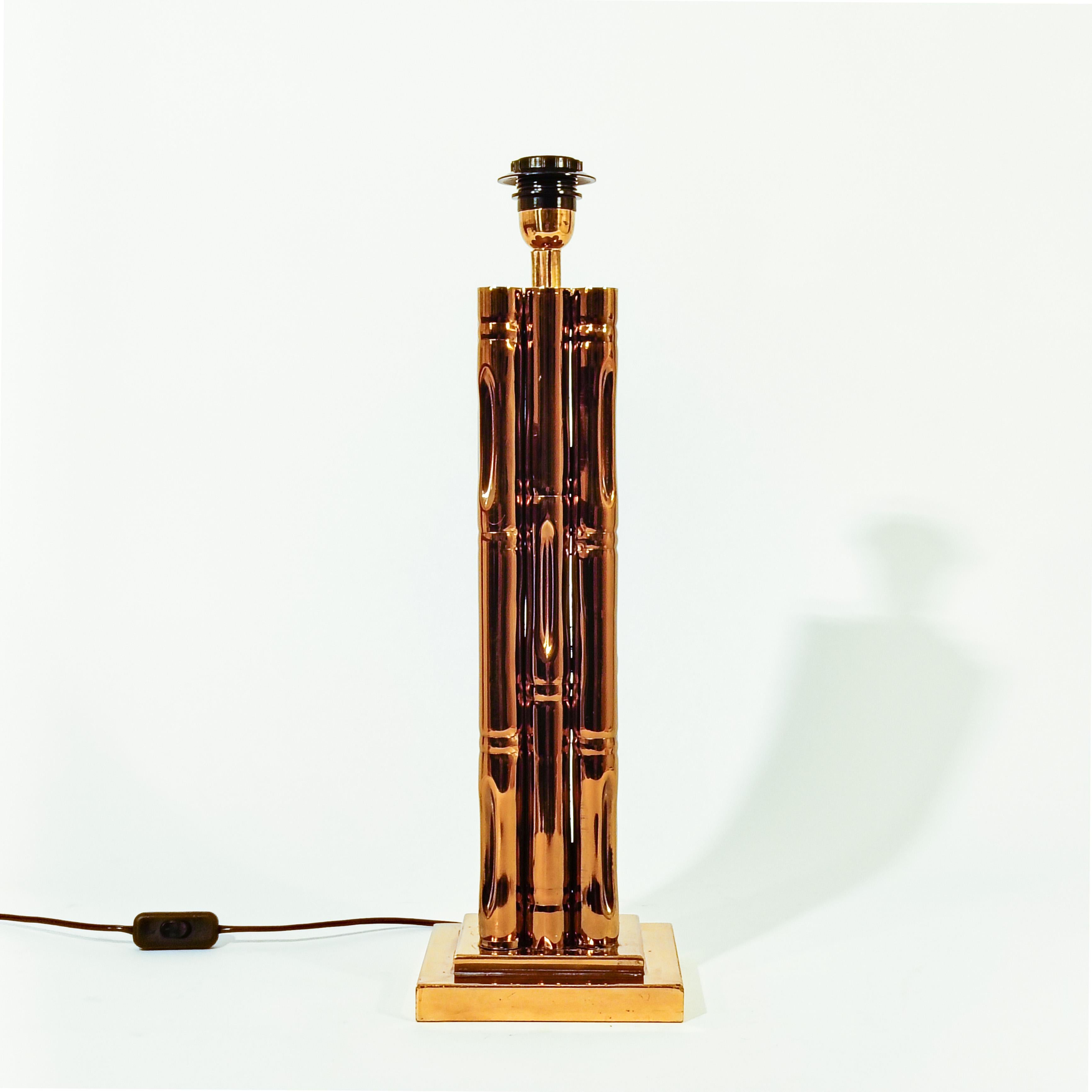 Lámpara de sobremesa de estilo Hollywood Regency y Riviera Francesa de Maison Jansen, Francia, años 70. Base cuadrada de metal cromado dorado sobre la que se asienta una estructura prismática que imita el bambú o la caña del mismo material.