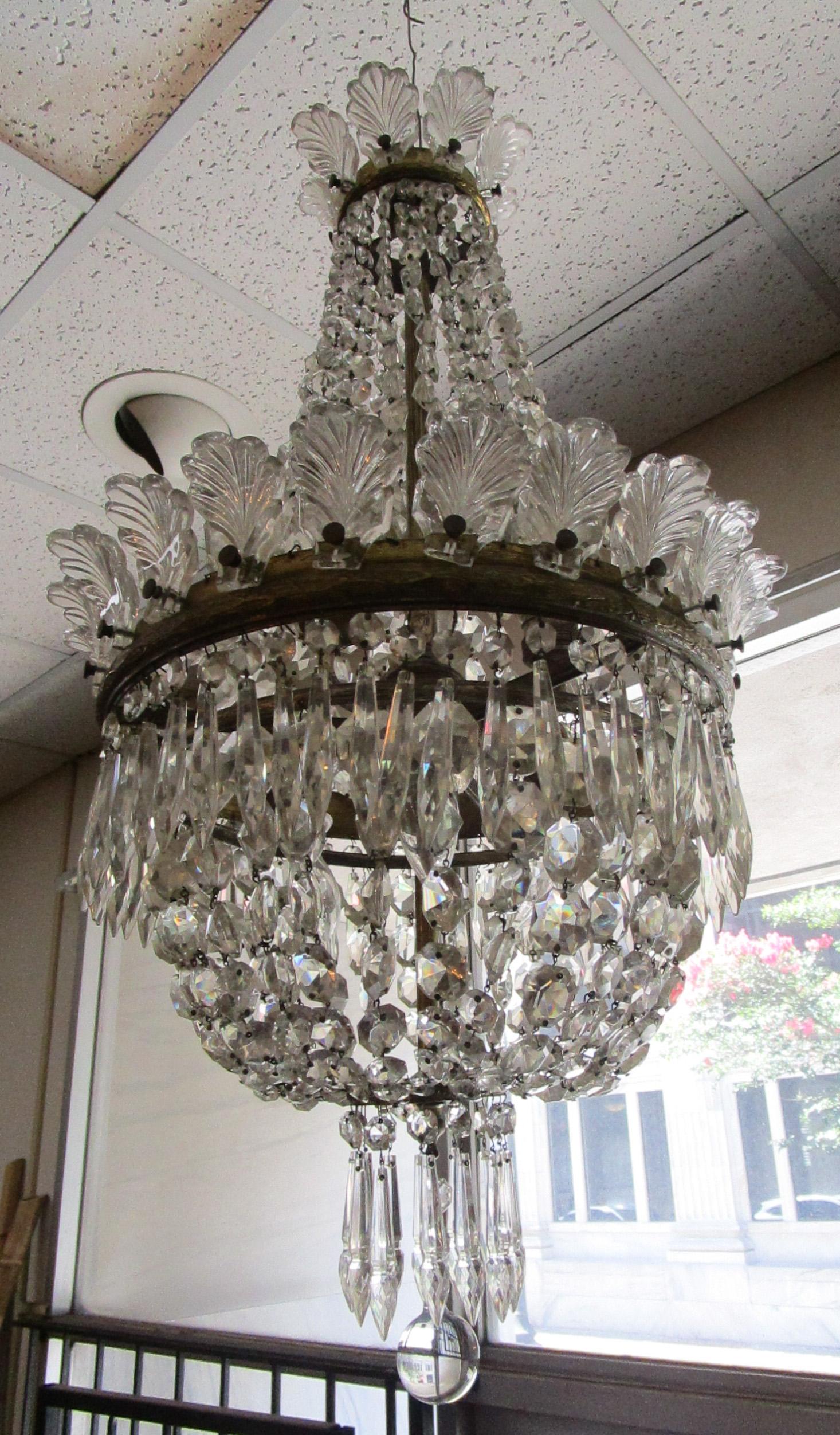 Questo splendido lampadario Hollywood Regency potrebbe essere stato utilizzato dai famosi designer Dorothy Draper e Billy Haines. Caratterizzato da un'elegante forma allungata, si distingue per gli scintillanti prismi a goccia, i festoni di perline,