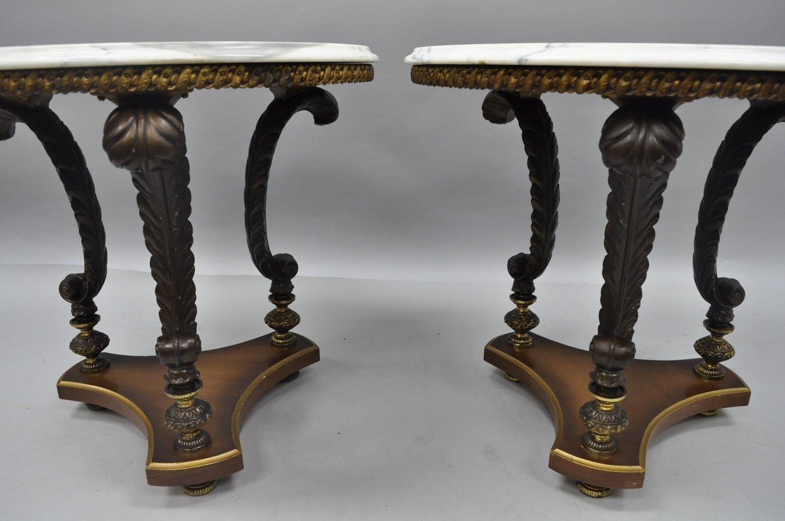 Pair of vintage Hollywood Regency French style marble-top side tables. Round marble tops, white metal plume supports, wooden base, metal feet, circa mid-20th century. Measurements: 22