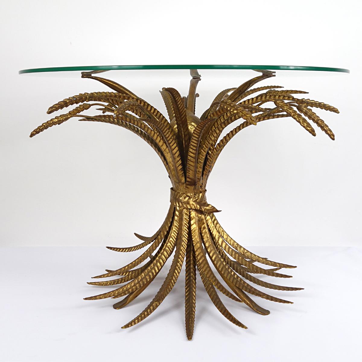 Gorgeous occasional or coffee table consisting of a nature inspired base made of gilded sheaves of wheat, with a round glass top.
This is the kind of table the famous French designer Coco Chanel had in her acclaimed apartment interior. Très chic !