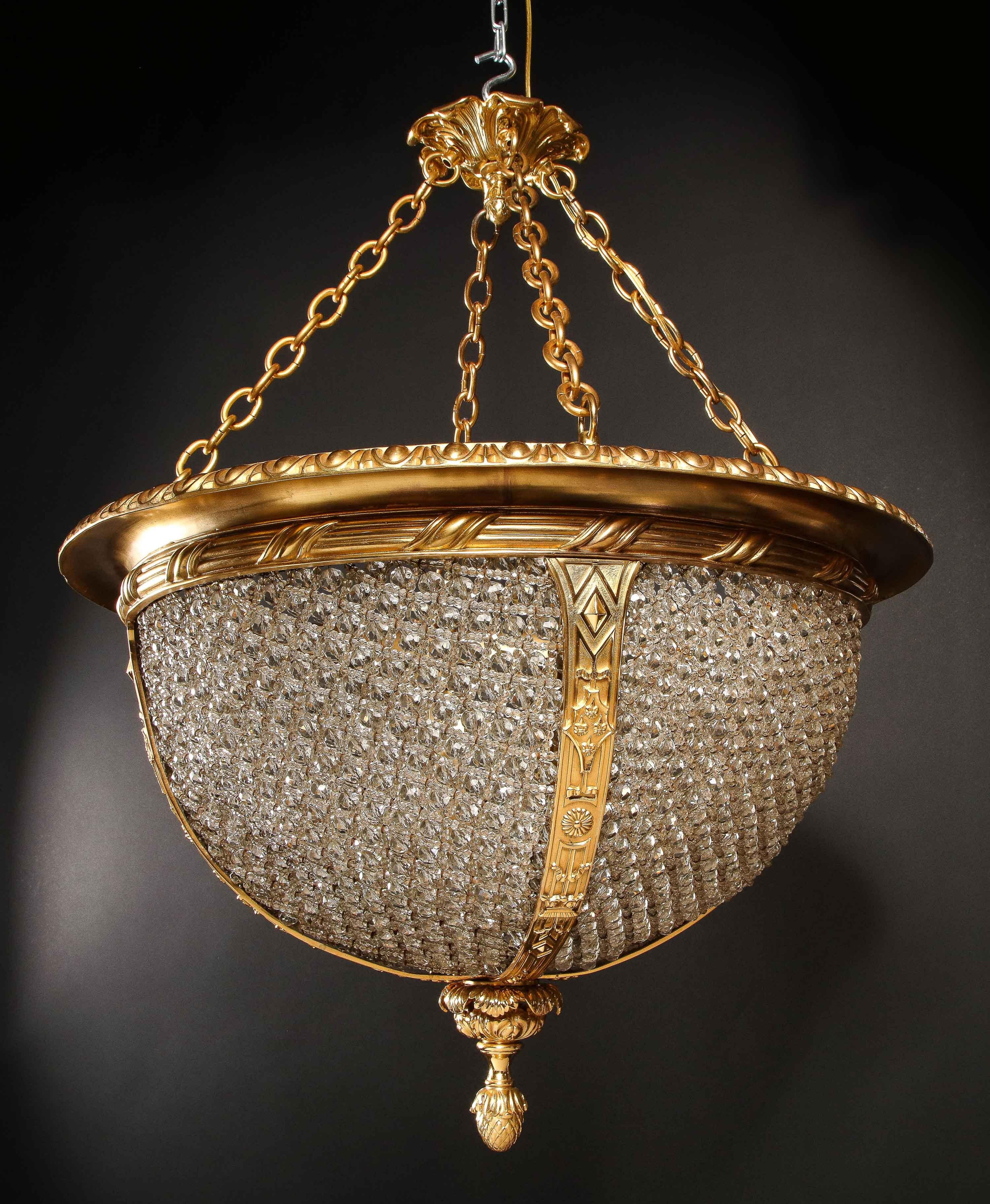 A Spectacular and Large Hollywood Regency Gilt Bronze and hand Beaded Glass Multi Light Chandelier of exquisite craftsmanship.  This rare chandelier is of circular form made of solid gilt bronze decorated with raised motifs embellished with many