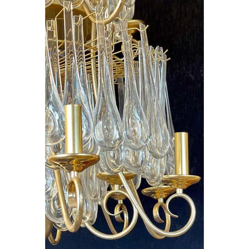 A finely cast gilt bronze tiered chandelier having large and impressive crystals. This one of a kind lighting fixture is simply stunning and certain to spark up conversation. 25 lights in total, having 4 lights on the top, 4 lights on the 2nd tier,