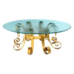 Table basse de style Hollywood Regency en fer doré à volutes avec plateau en verre ondulé