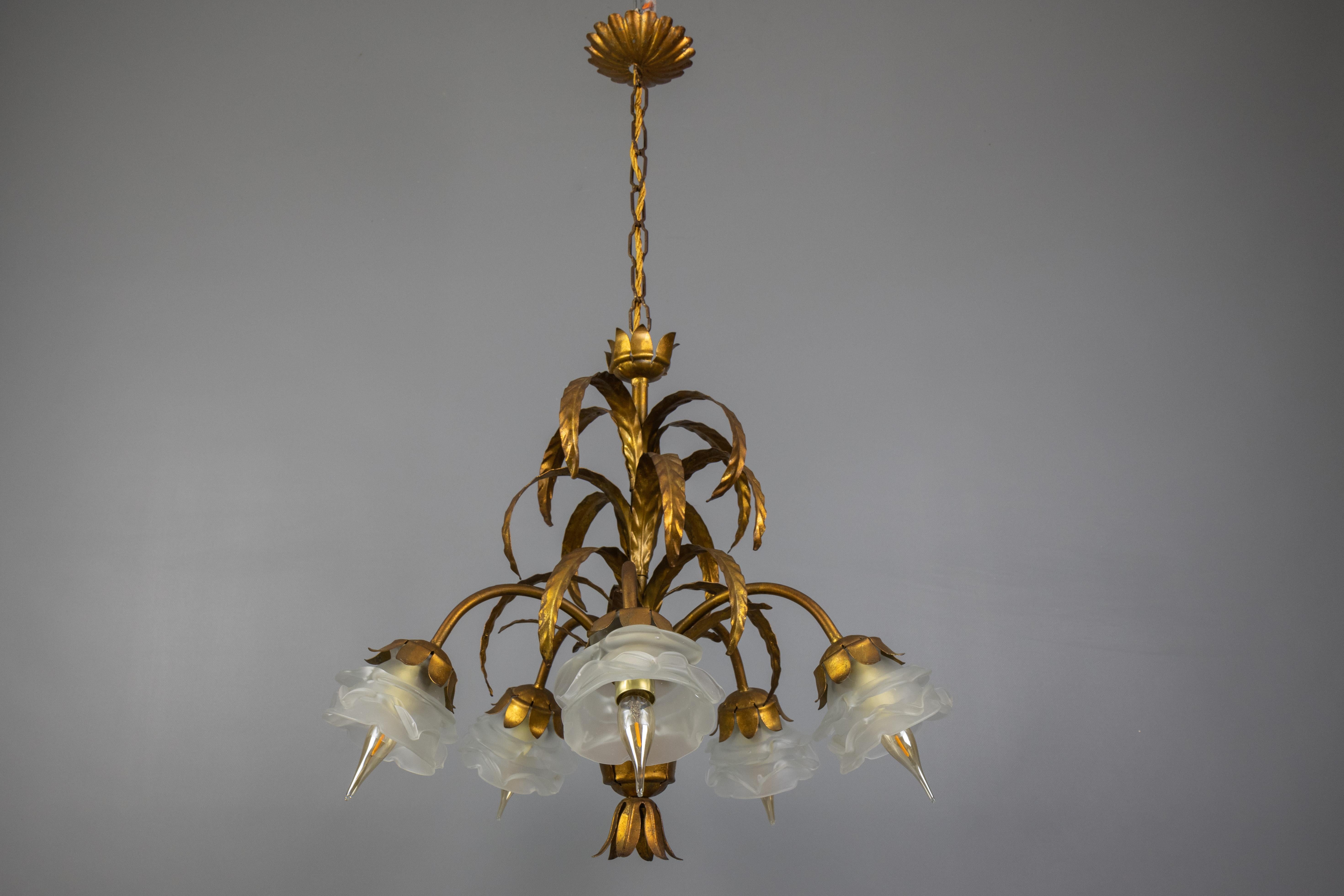 Lampadario Hollywood Regency in metallo dorato e vetro smerigliato bianco, Italia, anni '50 circa.
Questo delizioso lampadario italiano presenta un design a foglie in metallo dorato, cinque bracci, ciascuno con un paralume in vetro smerigliato