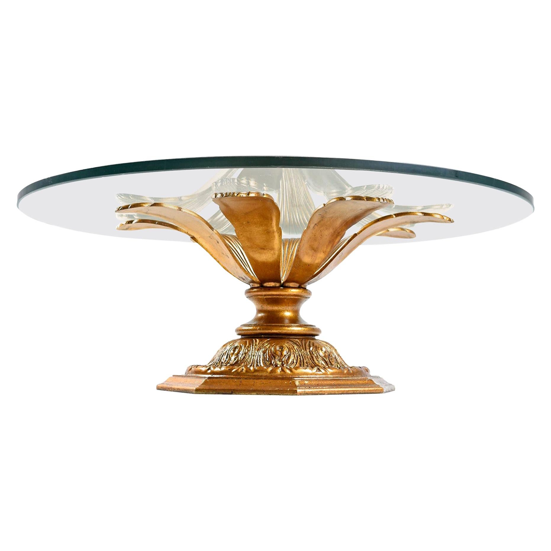 Spectacular vintage Hollywood Regency coffee table with new glass top. Heavy, metal base gilded with gold and black fleck color paint. Elegant blossoming form. Outstanding craftsmanship with steadfast construction. A functional work of art sure to
