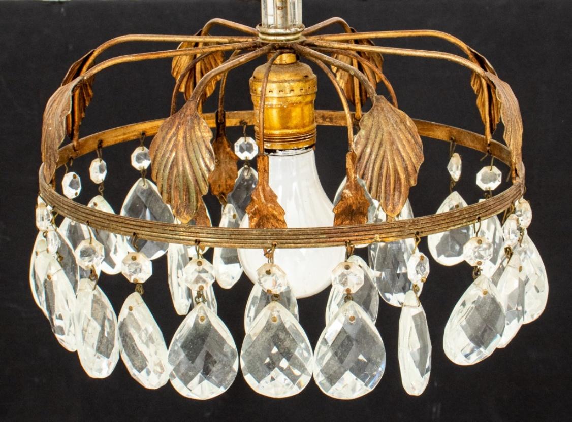 Hollywood Regency gilt metal ceiling pendant 1960s with leaf-form canopy and two concentric rings of cut-glass crystals surrounding a single light. In good vintage condition.

Dealer: S138XX.