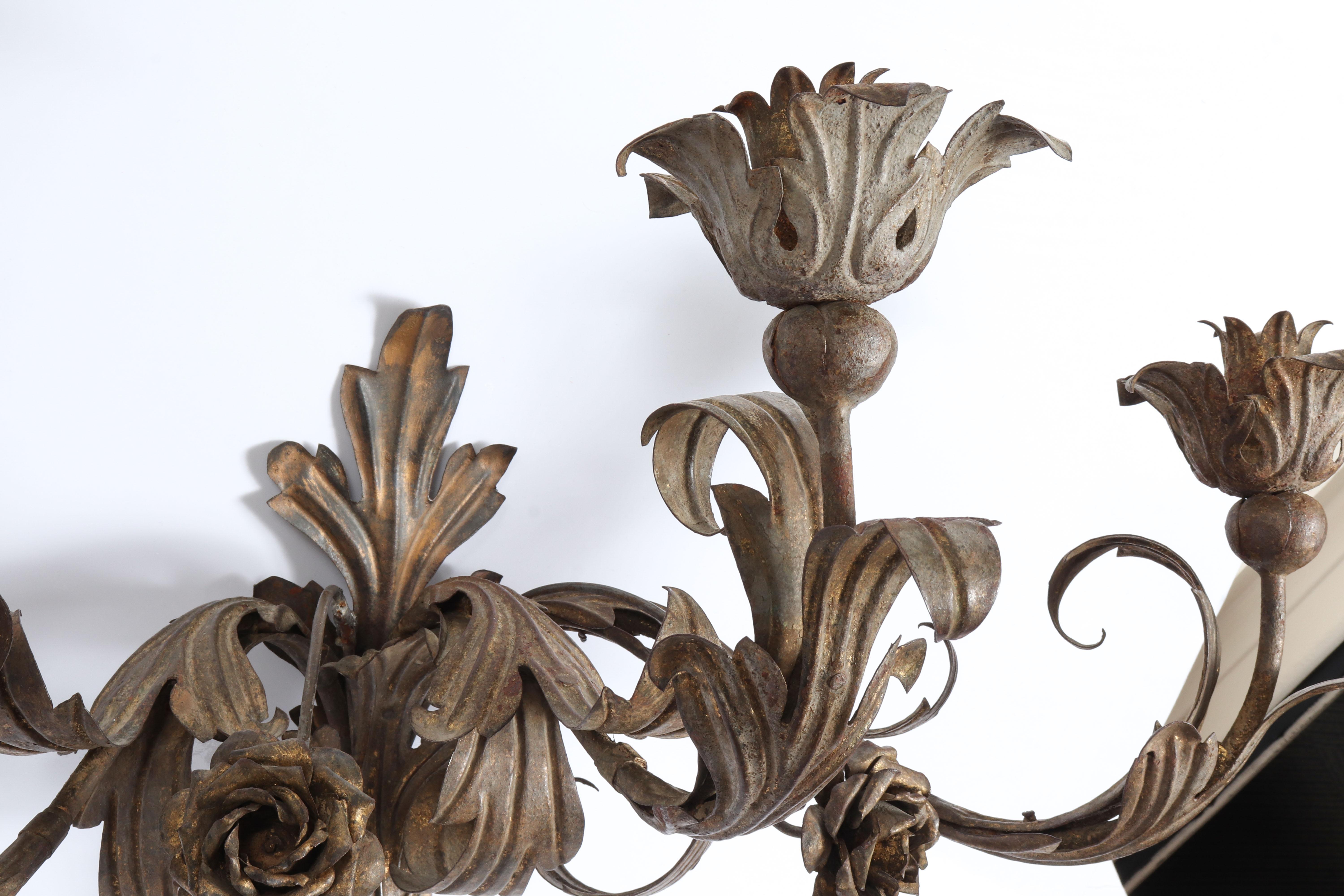 Hollywood Regency pair of wall sconces made in gilt metal. The pair is made with decorative roses and foliage and can fit three candles each. In great vintage condition with age-appropriate wear and use.

Dealer: S138XX