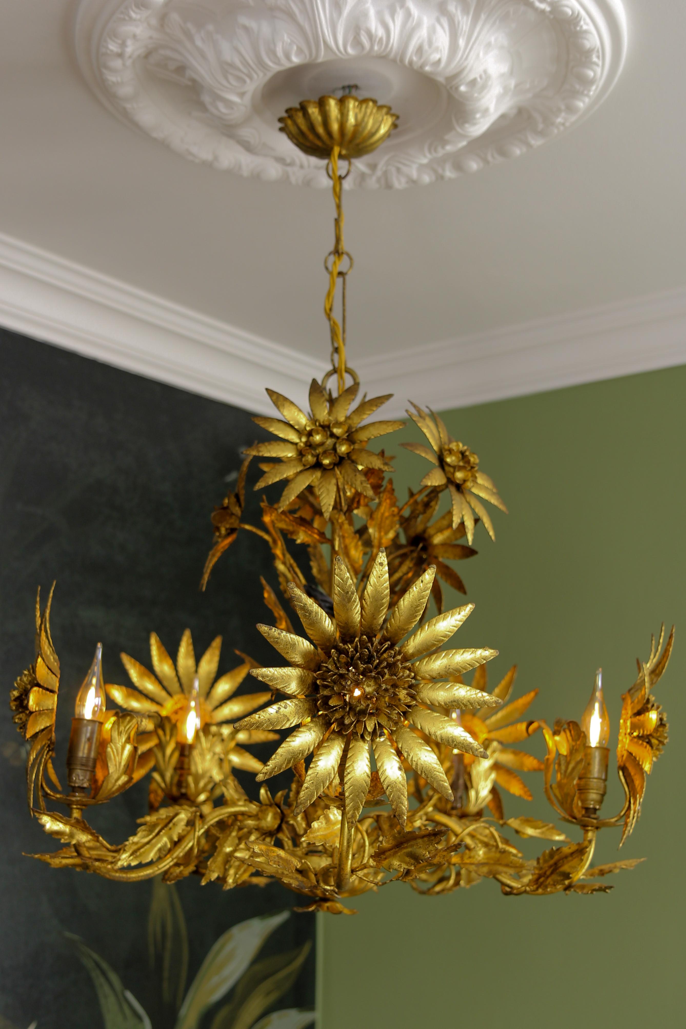 Hollywood Regency gilt metal flower five-light chandelier, attributed to Hans Kögl, from ca. the 1950s.
This exceptional and rare chandelier is made of gilt metal and is adorned with beautifully shaped large flowers, smaller flowers, and leaves.
