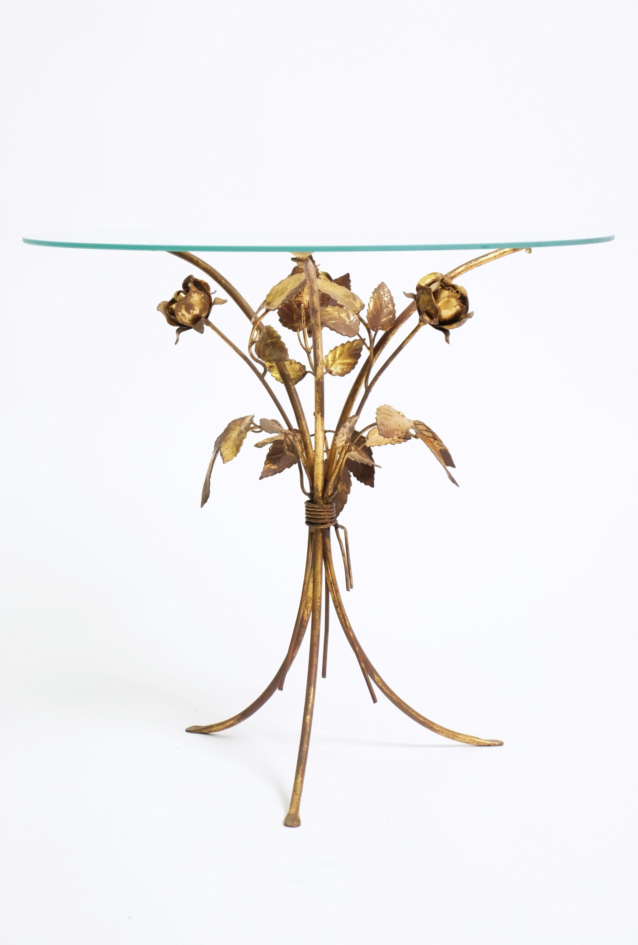 Magnifique table basse / table d'appoint dorée à motifs floraux datant des années 1970. En forme de bouquet de roses, fait à la main en métal doré avec un couvercle rond en verre. Le cadre de la table est en bon état avec une charmante patine sur le