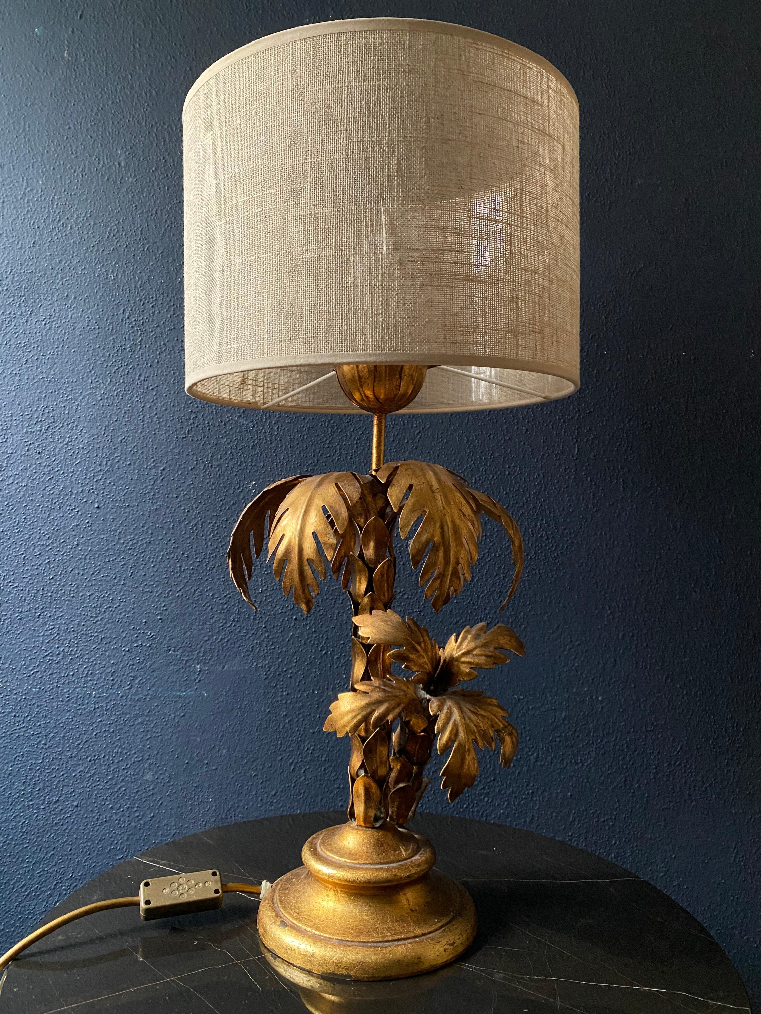 This elegant tree table lamp was designed by the illustrious German designer Hans Kögl and hails from the 1970s

Set on a round base, the body is made of small gilt metal plates arranged around the central rod like the trunk of a palm tree. There is