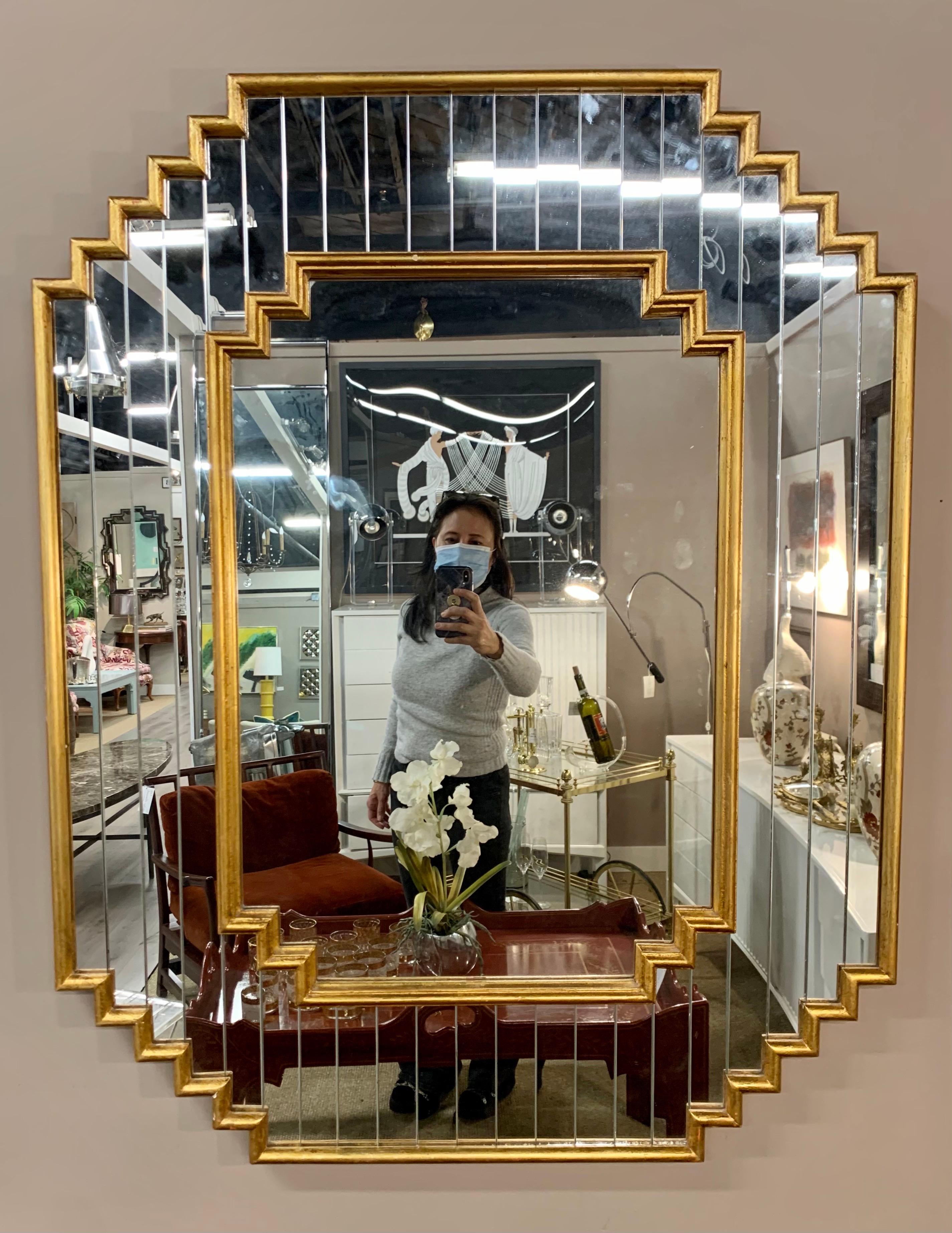 Exquisite Hollywood Regency mirror has a frame of vertical faceted mirrors and a giltwood outer and inner frame.