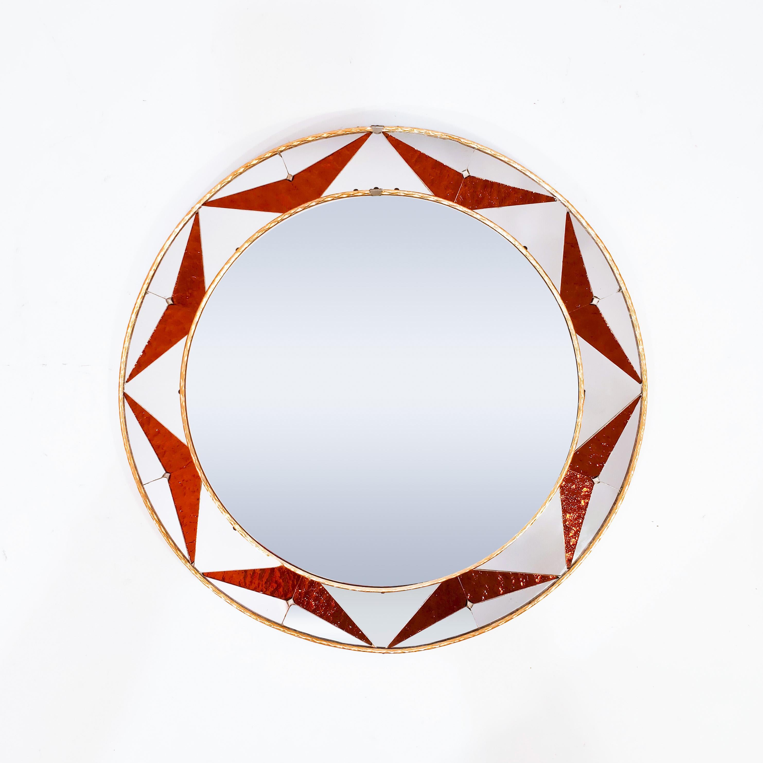 Sunburst style circular mirror with hand-made art glass mosaic, Spain, 1960s. Frame formed by textured artistic glass tiles as an iridescent mosaic in orange combined with mirror pieces, creating an effect reminiscent of the sun's rays or diamond