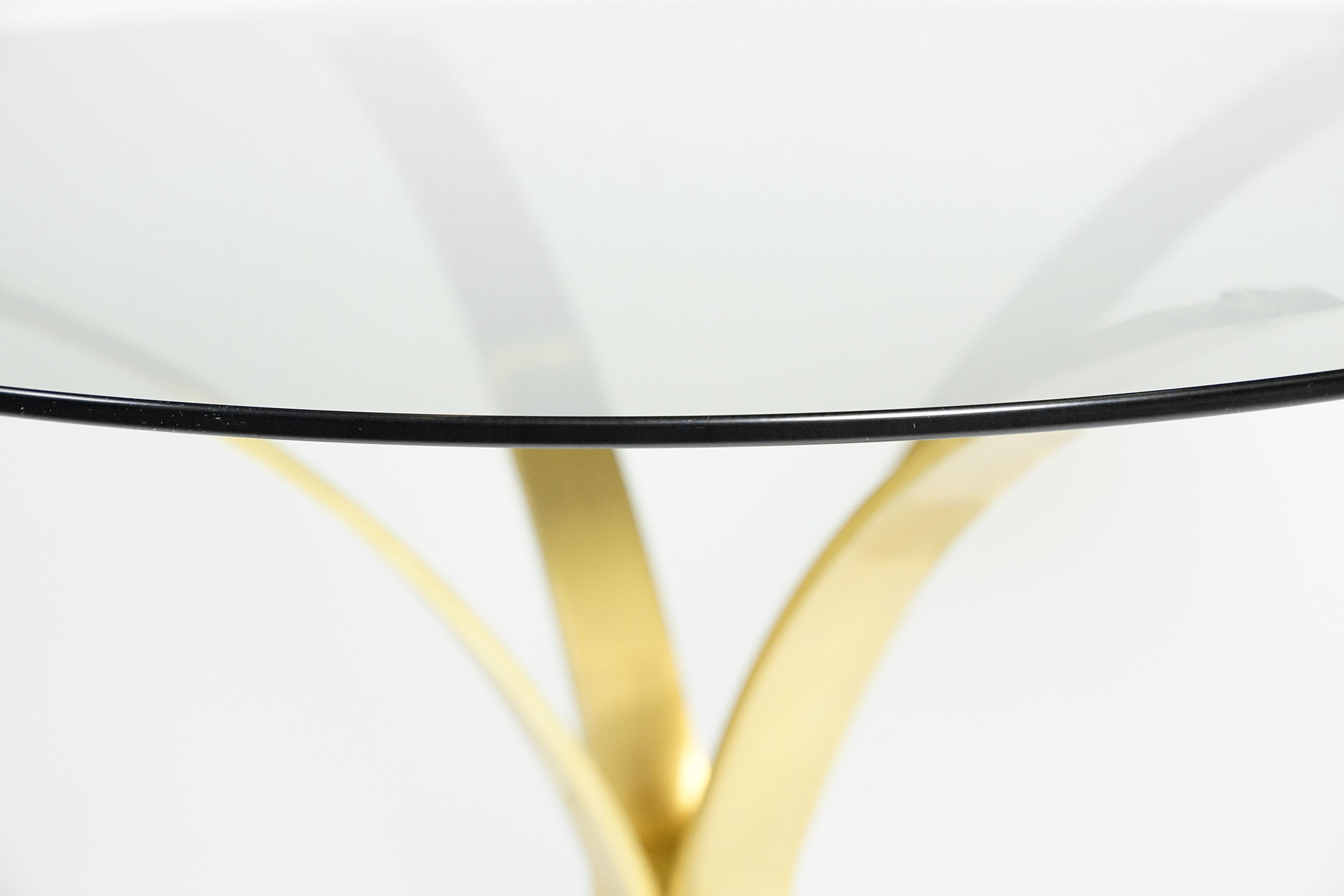 Glass table by Roger Sprunger for Dunbar, 1960s.
This wonderful piece of table has brass-plated curved legs and a round glass plate on top. Minor signs of use.