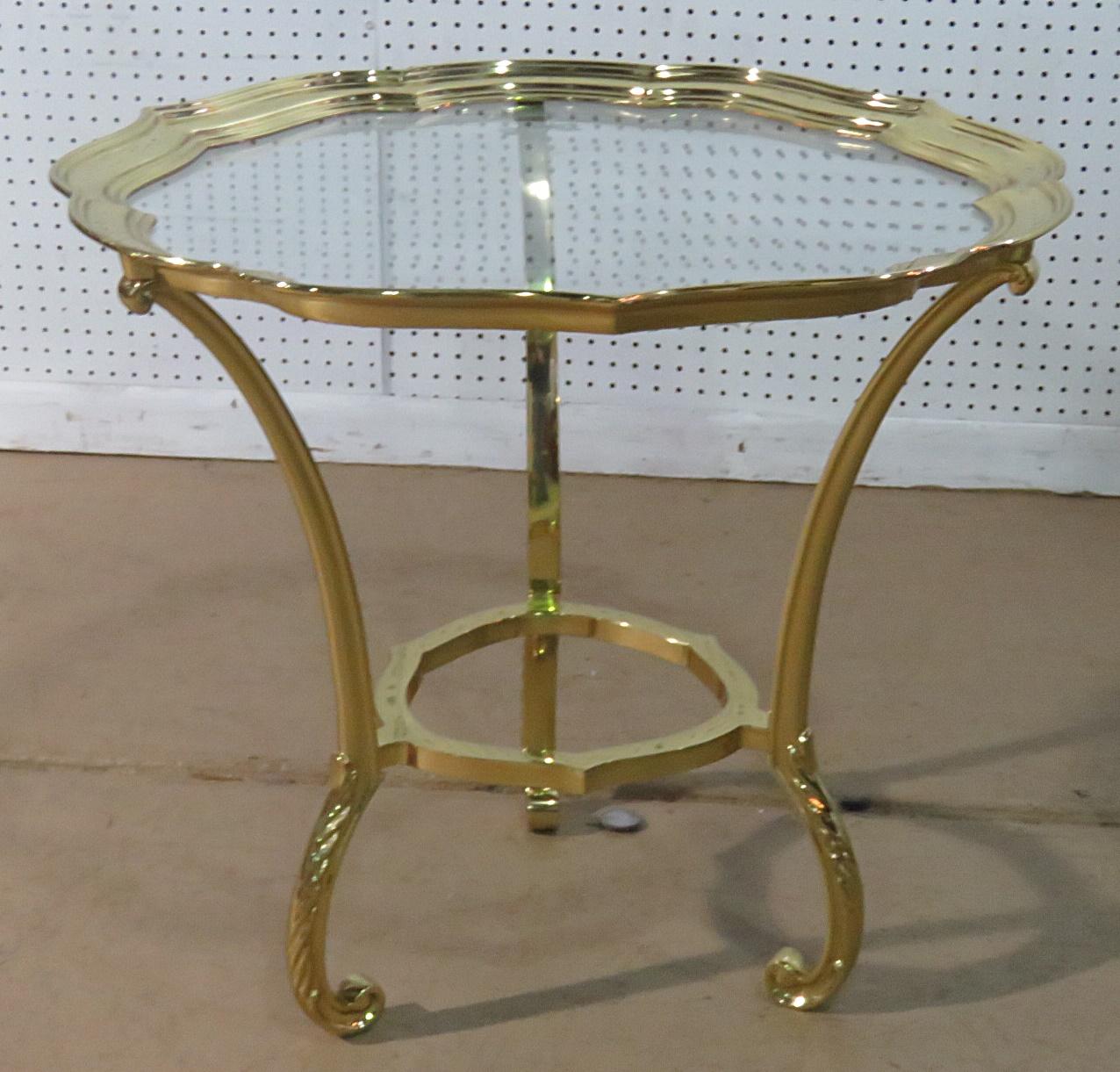 This is a gorgeous Hollywood Regency brass and glass top coffee table with a scalloped edge, attributed to Labarge. This table is the epitome of LaBarge's talent in designing glamorous furniture without going off the proverbial cliff and drifting