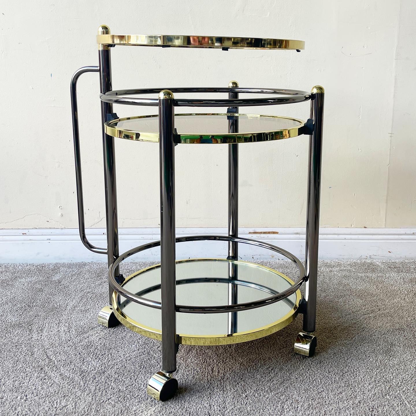 Incredible regency style bar/beverage cart. Top table swivels 360 degrees. Top two tiers feature a smoked glass with a mirrored bottom tier.

Additional Information:
Material: Glass, Metal
Color: Charcoal, Gold
Style: Hollywood Regency,