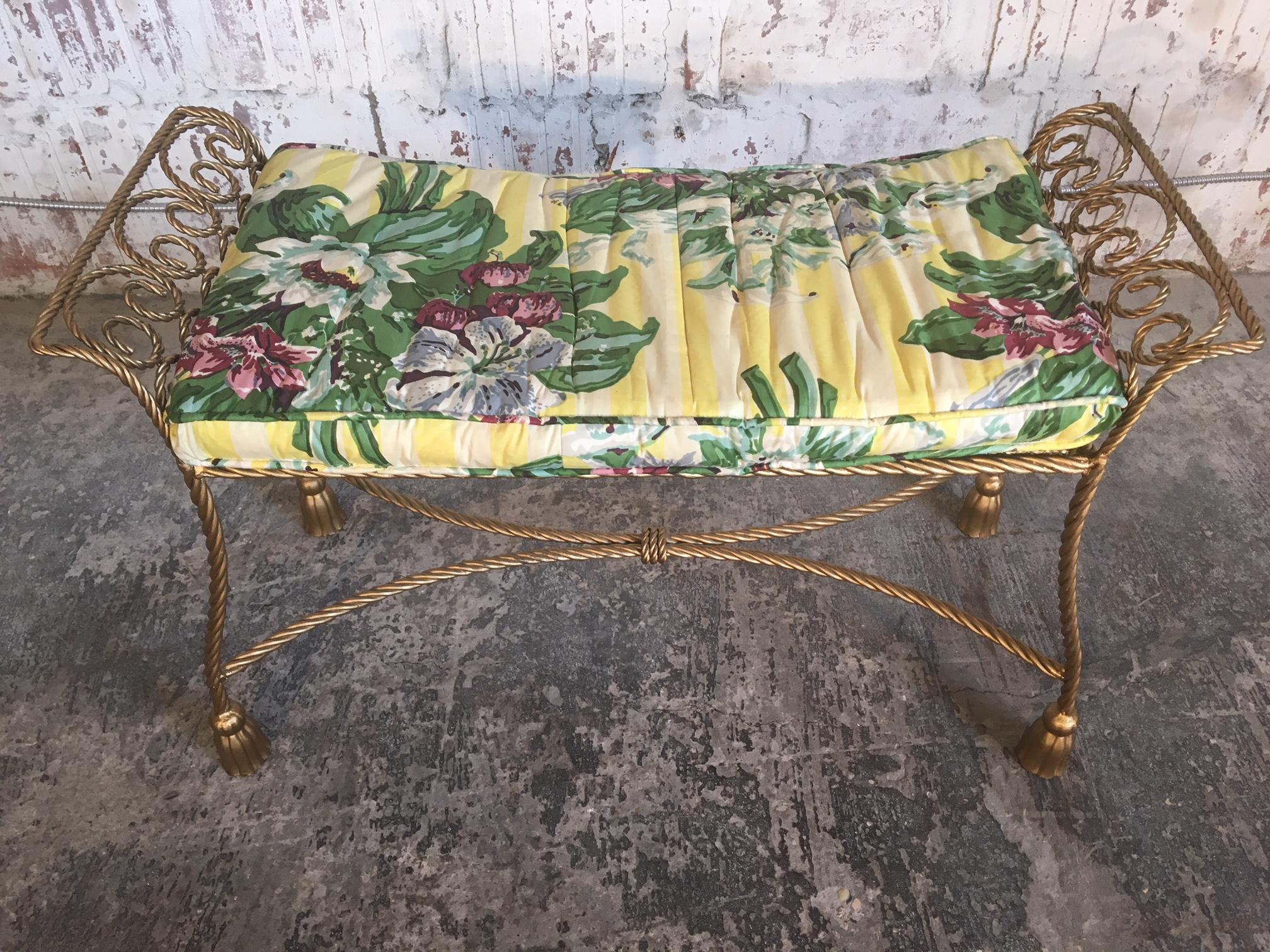 Vintage wrought iron vanity bench circa 1950s features twisted rope and tassel detailing. Very good condition.  Professional reupholstery available, inquire if interested.