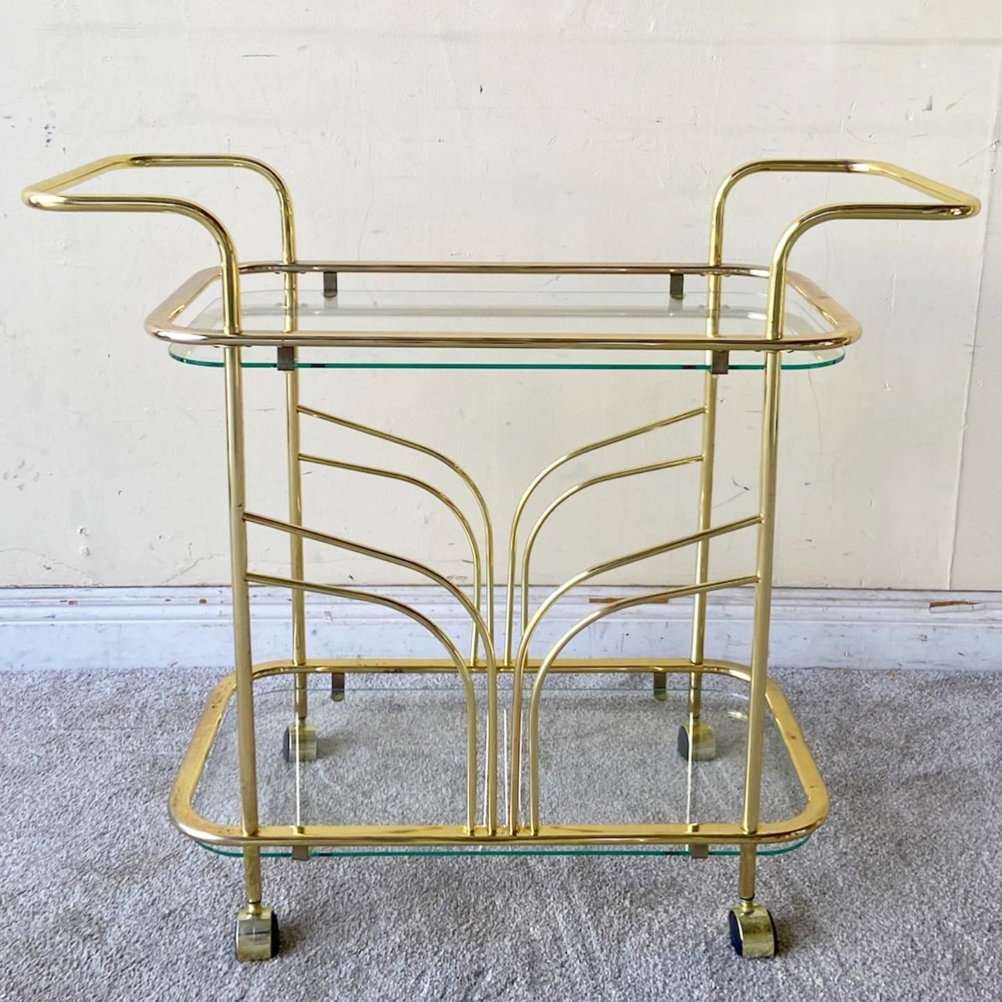 Amazing vintage Hollywood regency two tier bar cart. Features a fantastic gold finish with glass shelves.