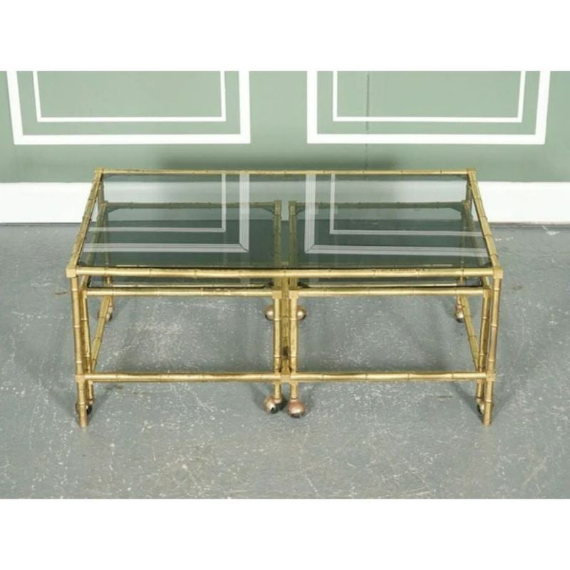We are delighted to offer for sale this Hollywood Regency golden bamboo coffee table Set with two side tables on castors.

Very classic-looking set, all three tables have a new black smoked glass. We slightly cleaned the frames to preserve the