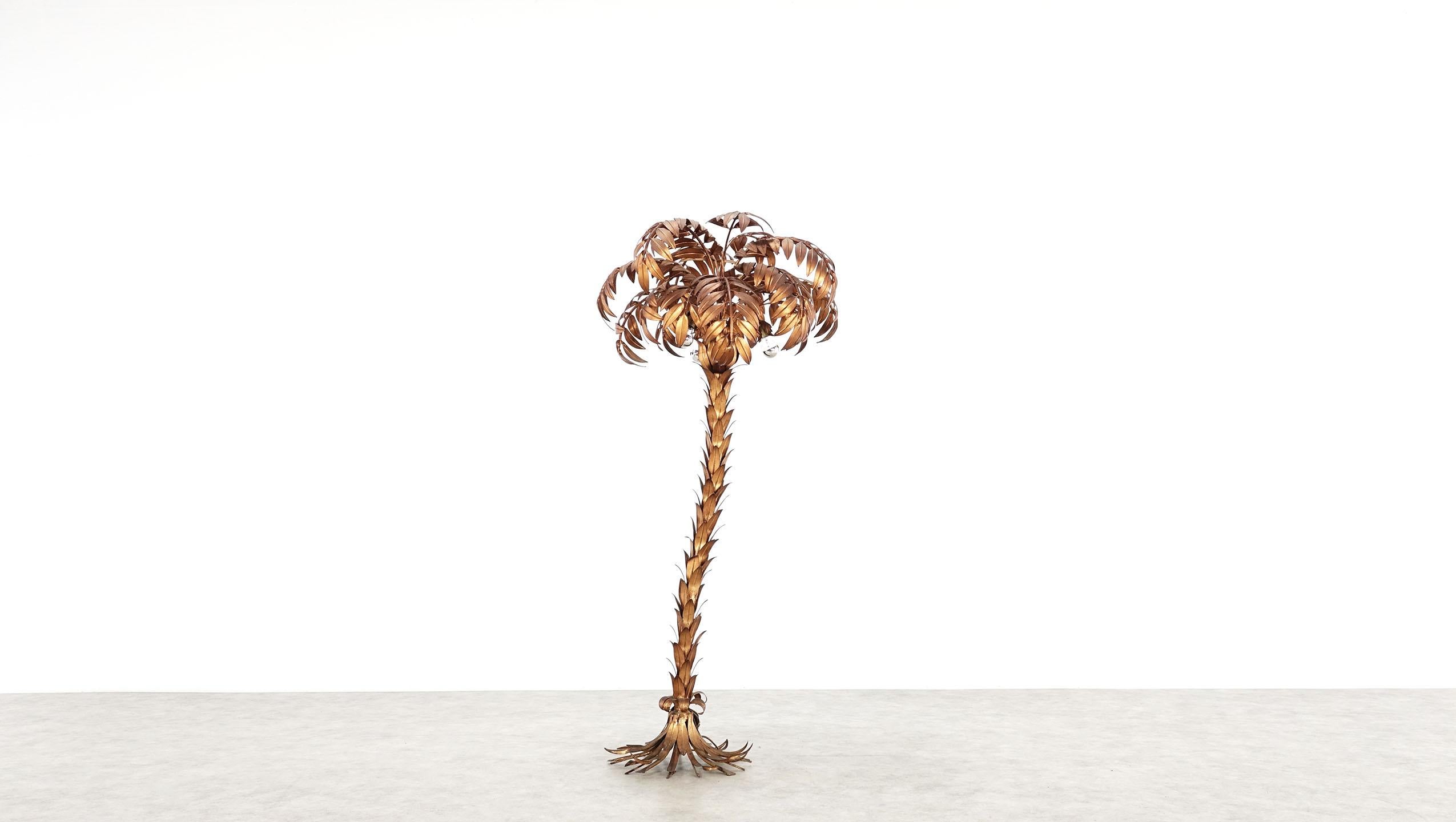 Hollywood regency style vintage golden palm tree floor lamp by Hans Kögl, very good vintage condition. Three E 27 sockets are hidden in the tree crown and the bulbs create a wonderful warm light shine. A leaf missing from the stand.
The floor lamp