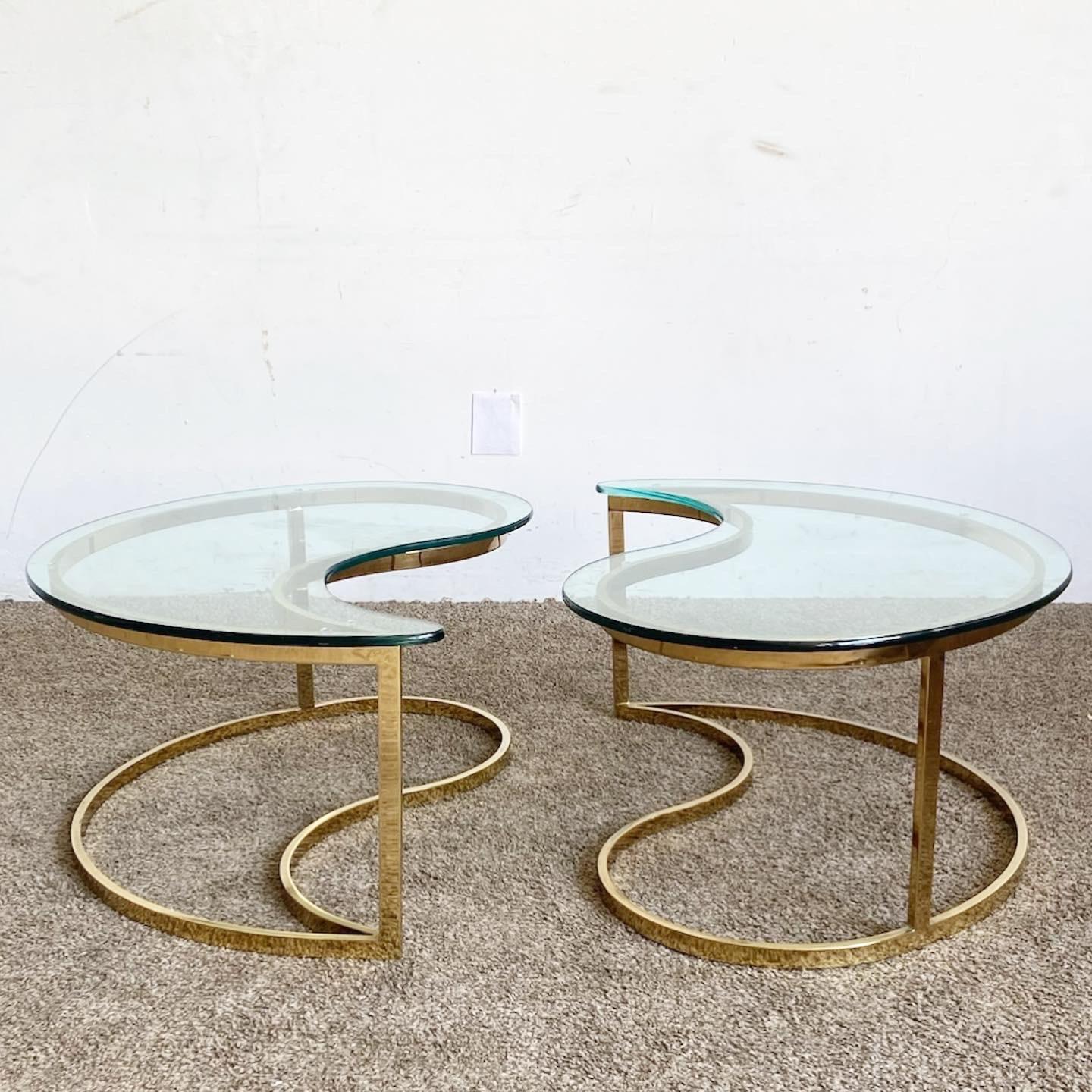 Introduce opulence and balance into your living space with this Hollywood Regency Golden Tear Drop Glass Top Coffee Table Set. Versatile in form and rich in style.
Minor pitting to the Golden Teardrop Coffee Tables as seen in the photos.