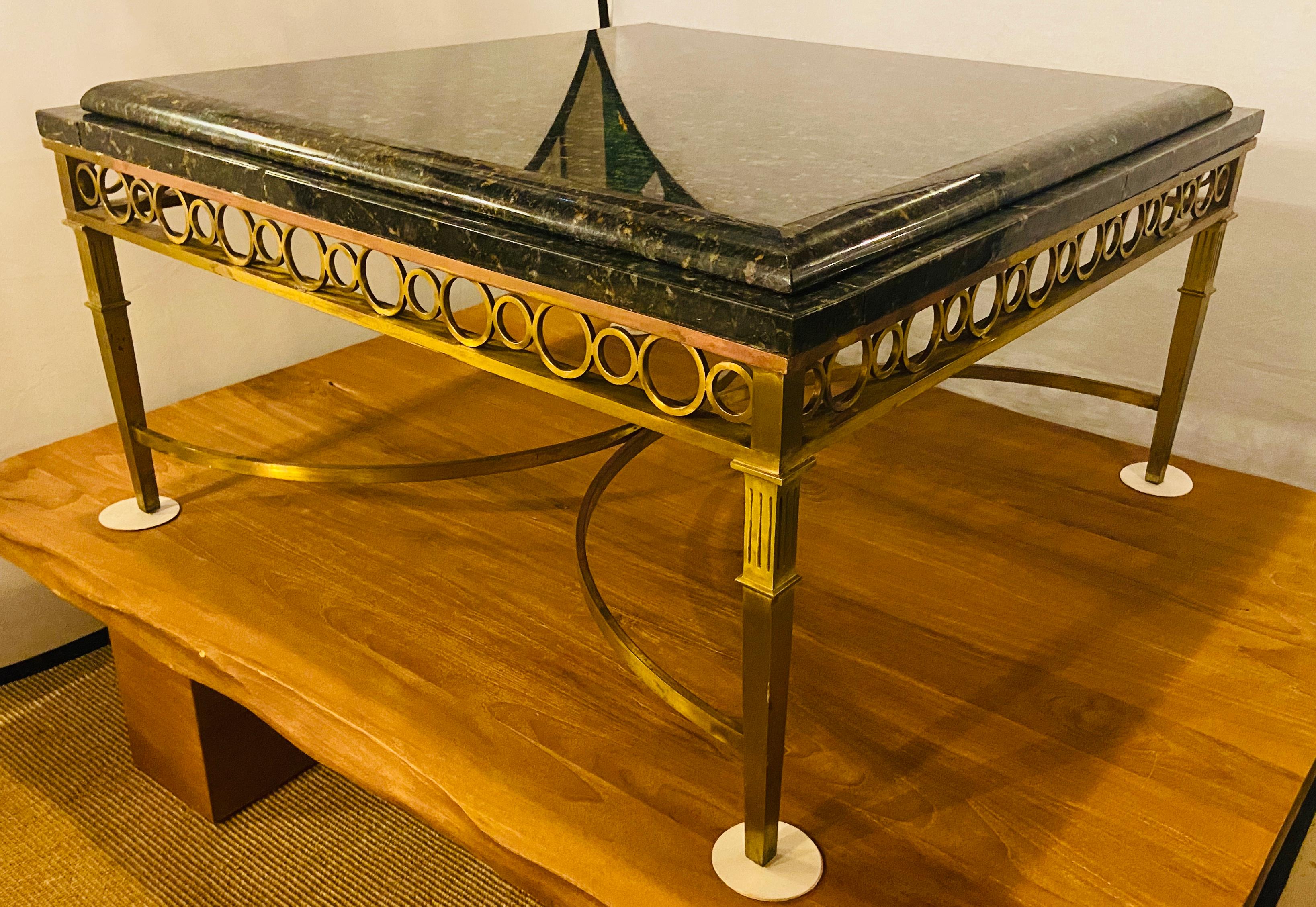 Hollywood Regency granite top on brass base center or cocktail table
This lovely square shaped Hollywood Regency center or cocktail table features a heavy granite top in dark green, yellow and black tones. The brass base is finely hand carved with