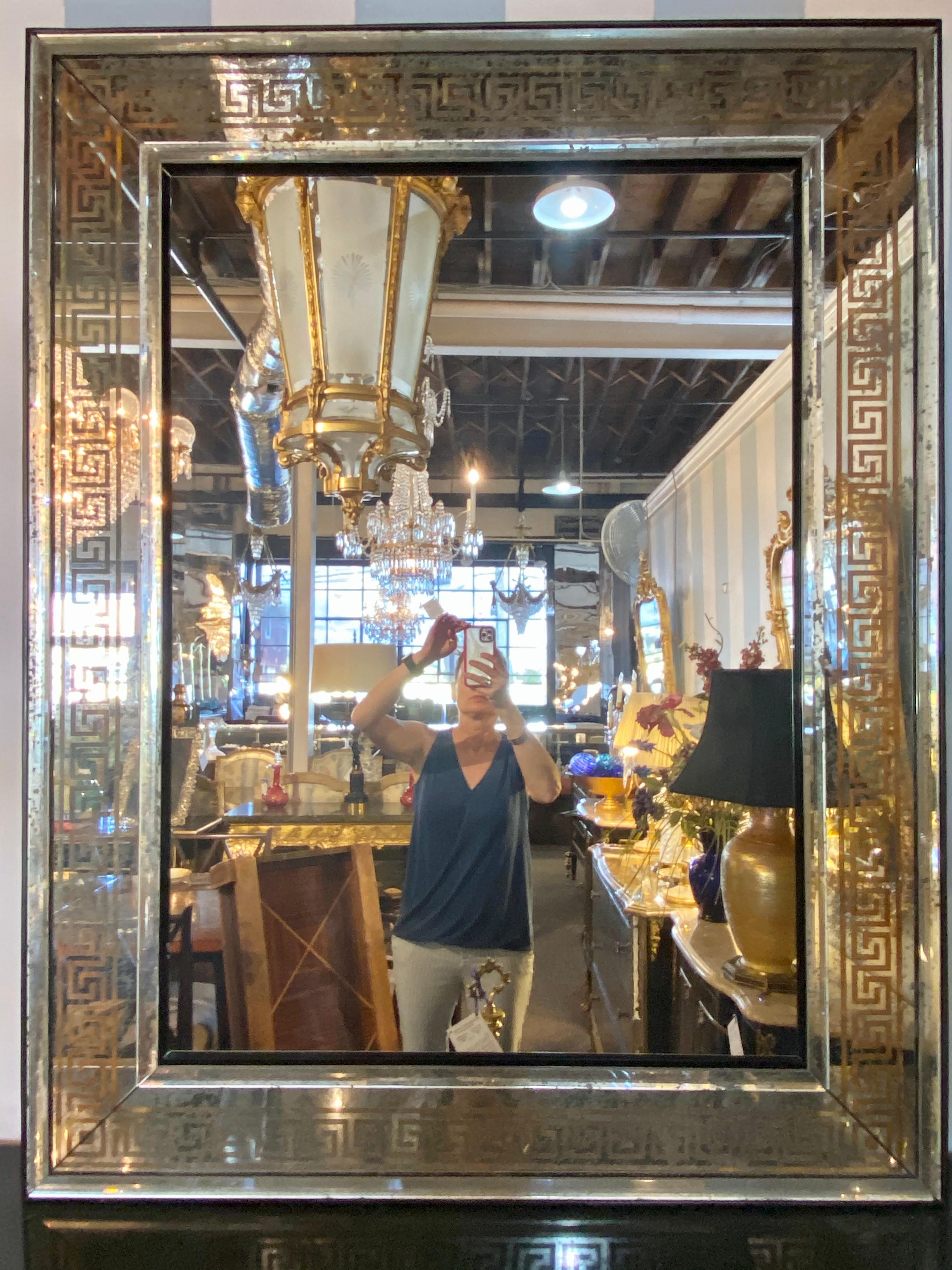 Hollywood Regency Bronze Greek key design wall, console pier mirrors. A pair of simply stunning custom quality mirrors. Each having a large gilt gold Greek key design border framed in beveled distressed mirror borders. The whole having a solid