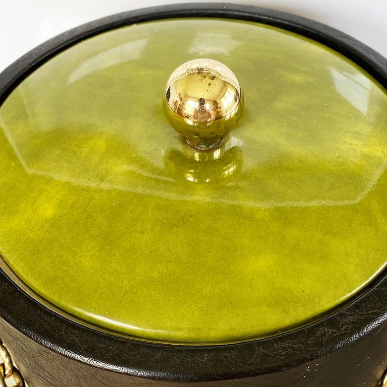 Elevate your entertaining with this tall green and black ice bucket by Georges Briard. This piece is shaped like a sprig of bamboo and is covered in marbled green vinyl and faux black leather. The bucket includes a gold chain for carrying. The lid