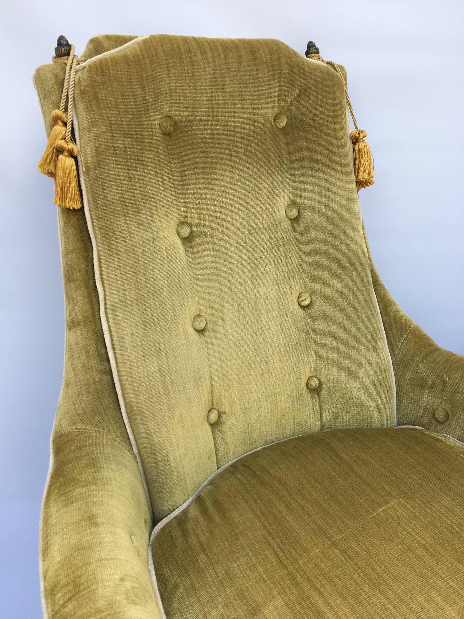 Perfect touch of Hollywood Regency in any home, these green velvet chairs by Perfection Furniture Company are adorned with brass finials and gold tassels. White piping accents. Excellent vintage condition with just one small fabric tear on rear of