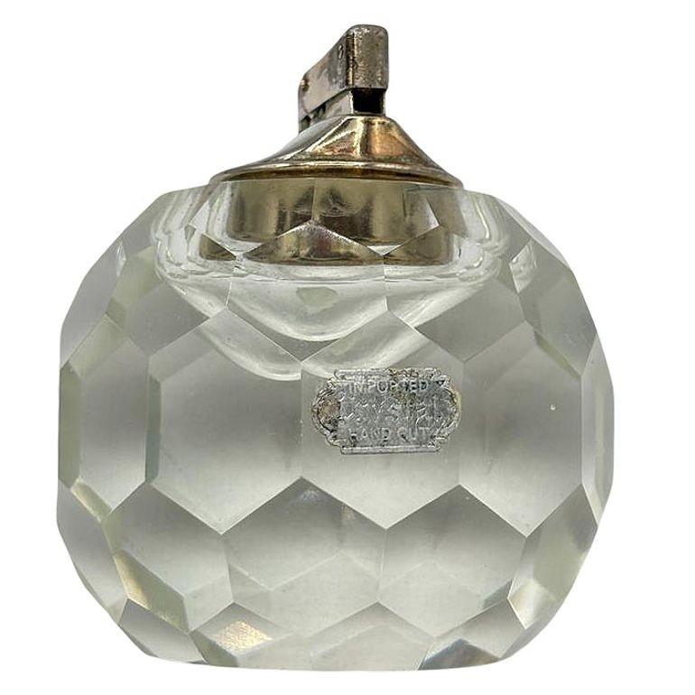Ce briquet de table en cristal vintage Hollywood Regency respire l'élégance et la sophistication intemporelles. Fabriqué à partir d'un cristal de haute qualité, il a une présence frappante, ce qui en fait un accent étonnant pour une table de