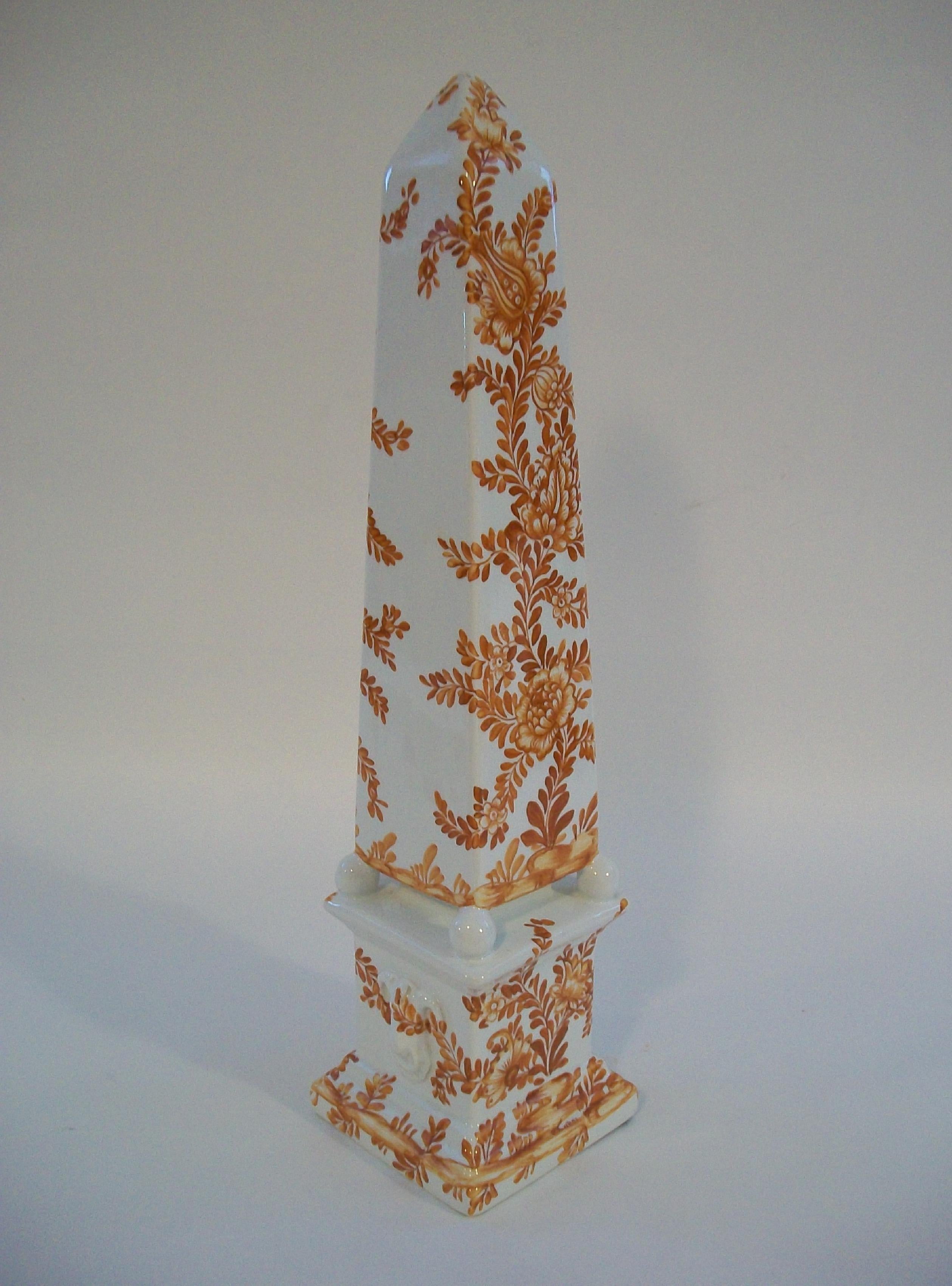 Obélisque en majolique peint à la main par le CIRCA - grand format - présentant un motif élaboré de fleurs et de vignes - base de style plinthe néoclassique avec quatre boules de support - signé sur la base - Italie - vers les années 1970.