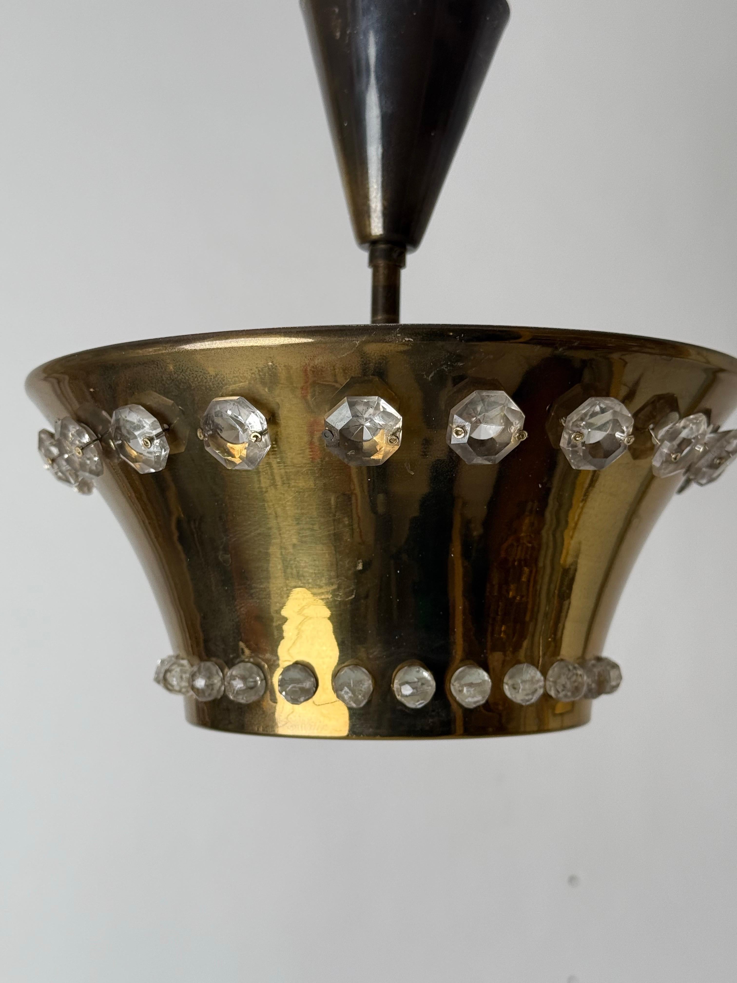 Elegant, schlicht und doch ein Schmuckstück, eine Raumdekoration und ein Zeichen für zeitlosen Designgeschmack, das verkörpert diese seltene Deckenleuchte. Diese kleine Lampe aus hochwertigem Messing und Kristallkugeln ist ein wahres Feuerwerk. Die