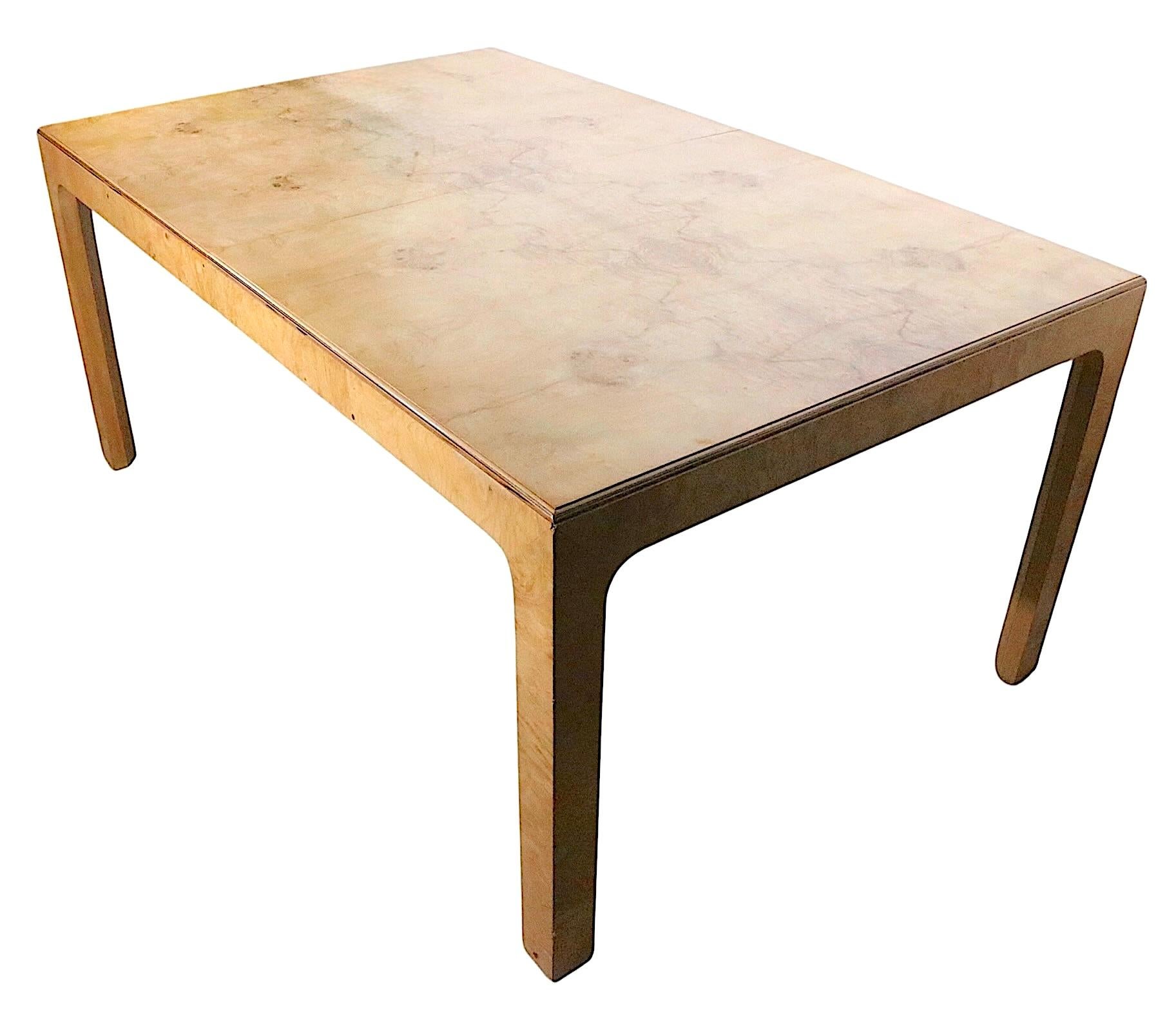 Voguish high style Hollywood Regency parsons form dining table, made by Henredon as part of their sought after Scene Two series. The table was executed in olive wood burl, and includes two 22