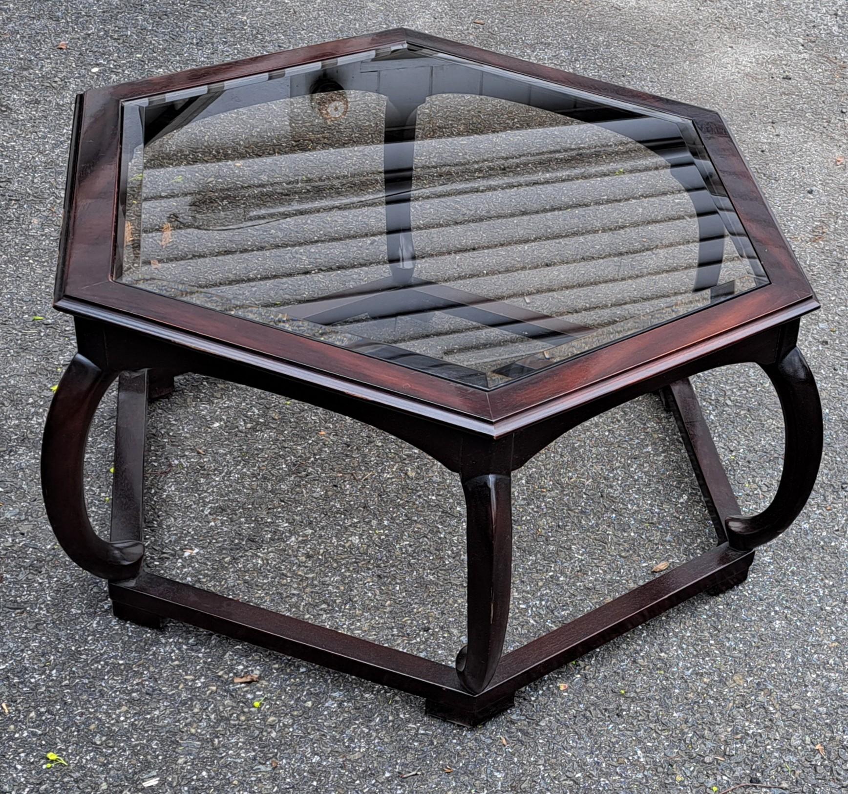 Elegant hexagonal Hollywood Regency style coffee table with custom glass top and curved supports.
