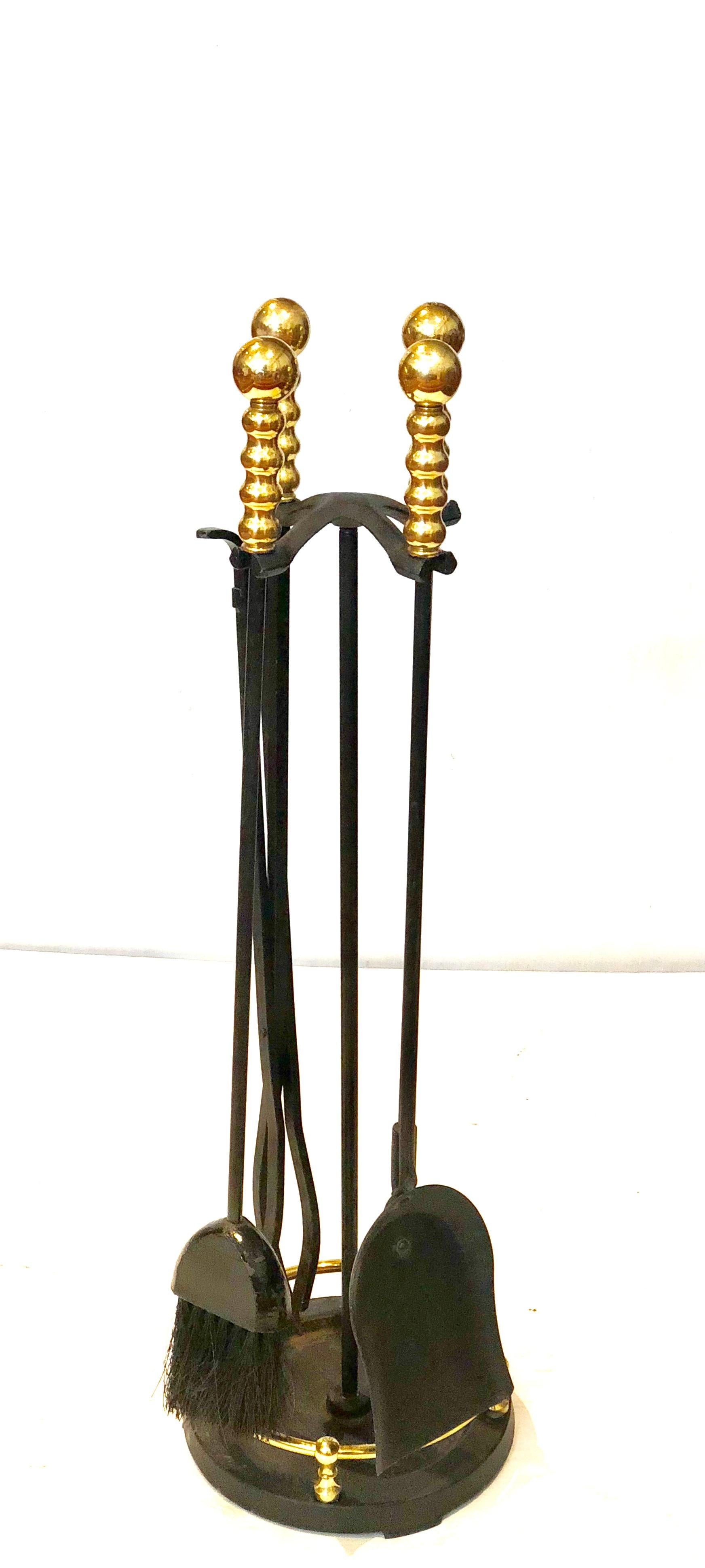 Elegant brass and iron fireplace tool set with beautiful solid brass handles, circa 1970s. Amazing quality; very heavy with nice detail on the handles. Set includes a shovel, brush, poker and log holder.