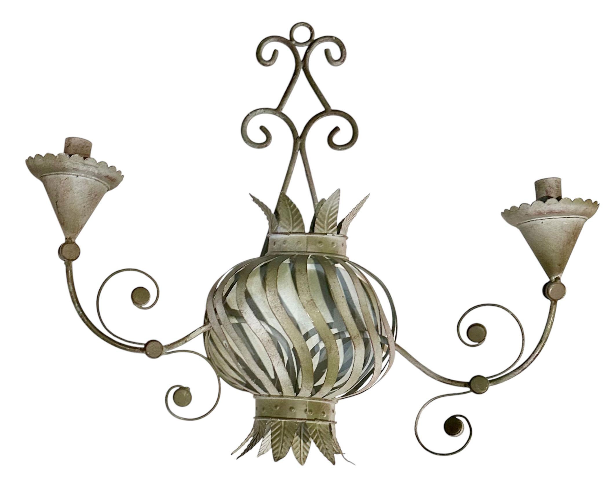 Un exquisito par de candelabros de hierro y tole de la Regencia de Hollywood con intrincados detalles y un diseño atemporal, estos candelabros aportan elegancia y encanto a cualquier pared.  