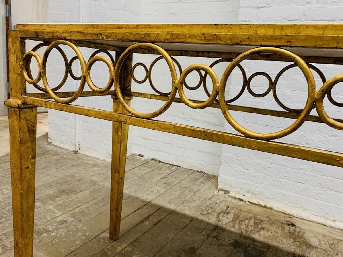 Hollywood Regency iron gold gilt marble-top console. Console has decorative circled pattern with a marble top.