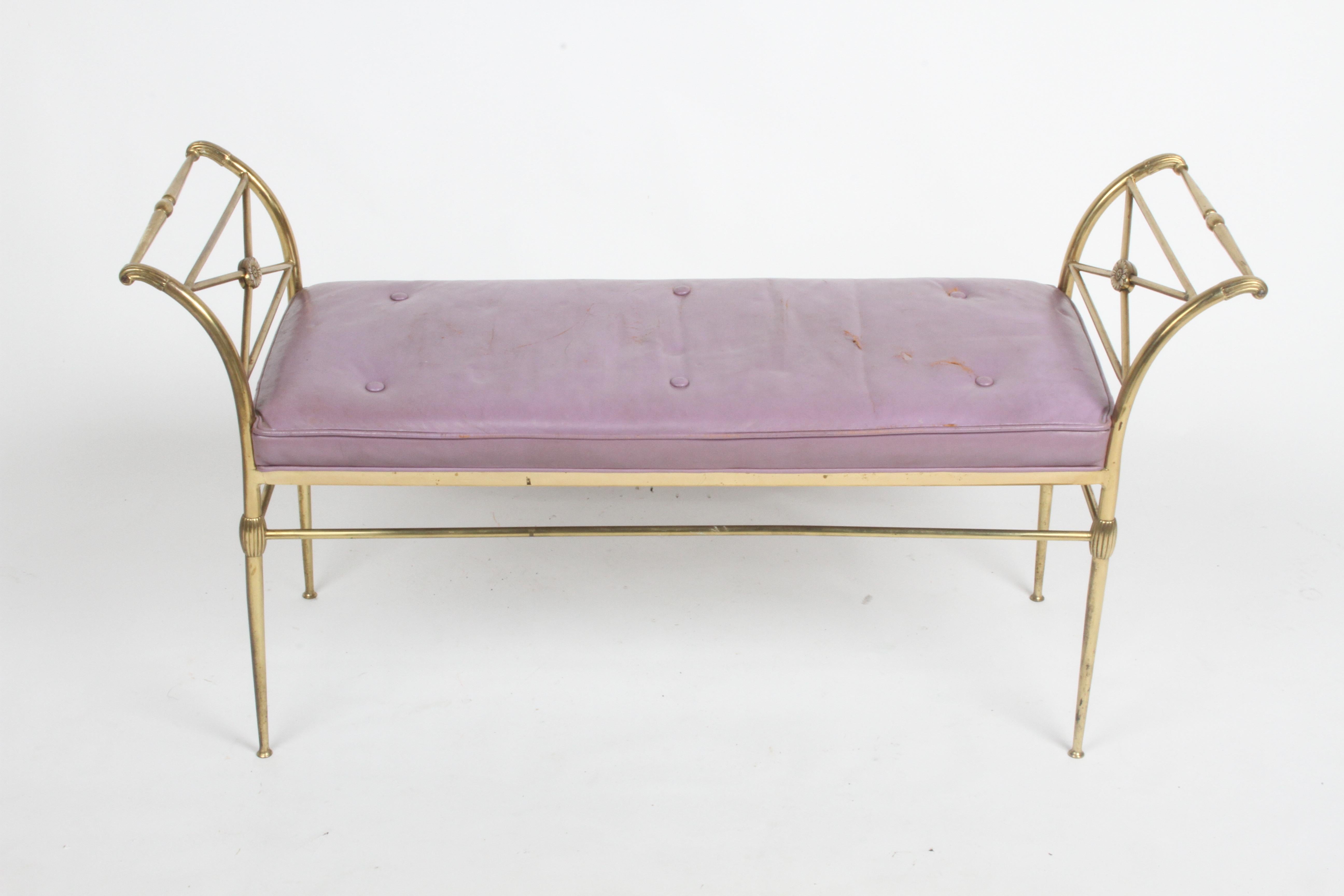 Vintage Hollywood Regency Italian brass bench with a neoclassical flair with original purple leather seat cushion. Brass frame arms have X form supports with oval decoration, lower cross supports with fluted detail. Brass shows patina, leathers
