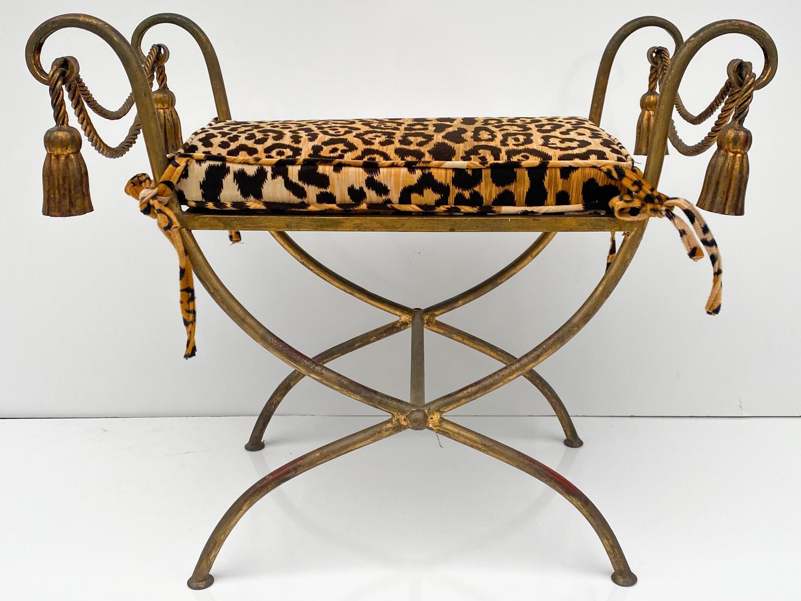 This is a pair of Hollywood Regency era Italian gilt metal benches newly upholstered in a leopard velvet. The frames show lite age wear to the gilt. The cushions are 2 inches in height.